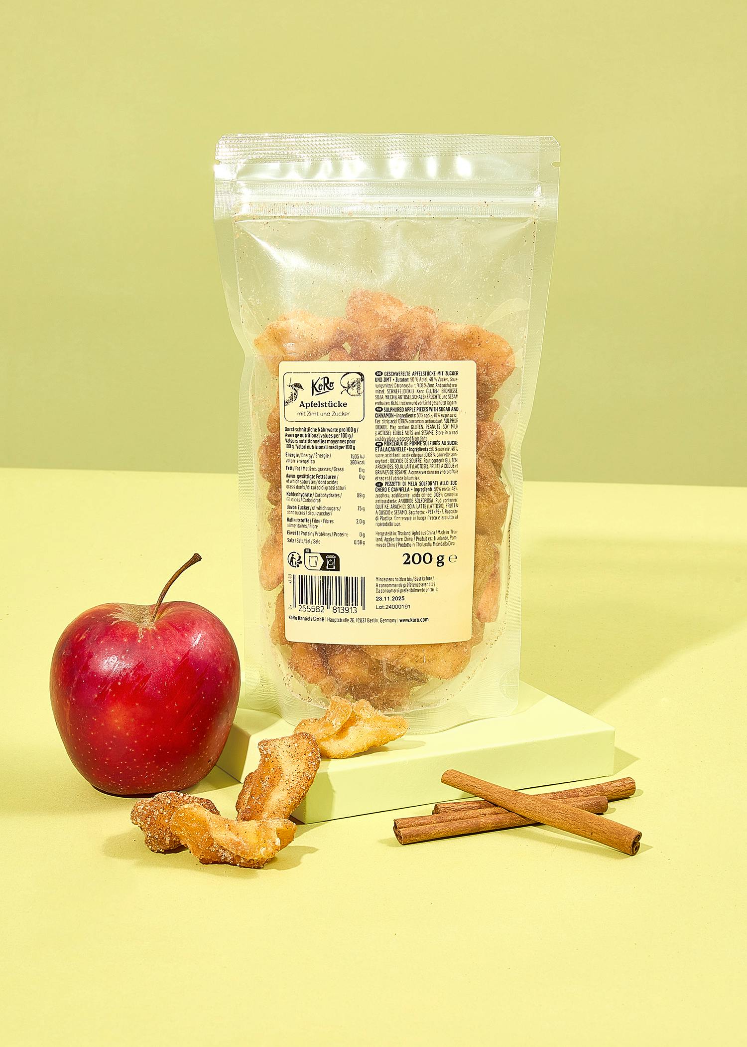 eine Tüte mit einem Etikett auf der Rückseite steht neben einem Apfel und Zimtstangen