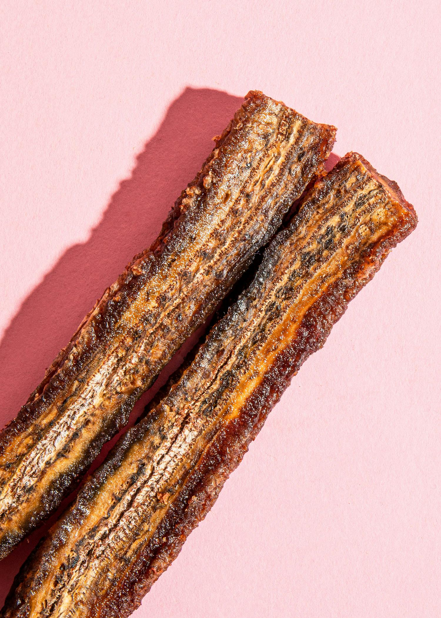 eine Nahaufnahme von zwei Bananensticks auf einem rosa Hintergrund