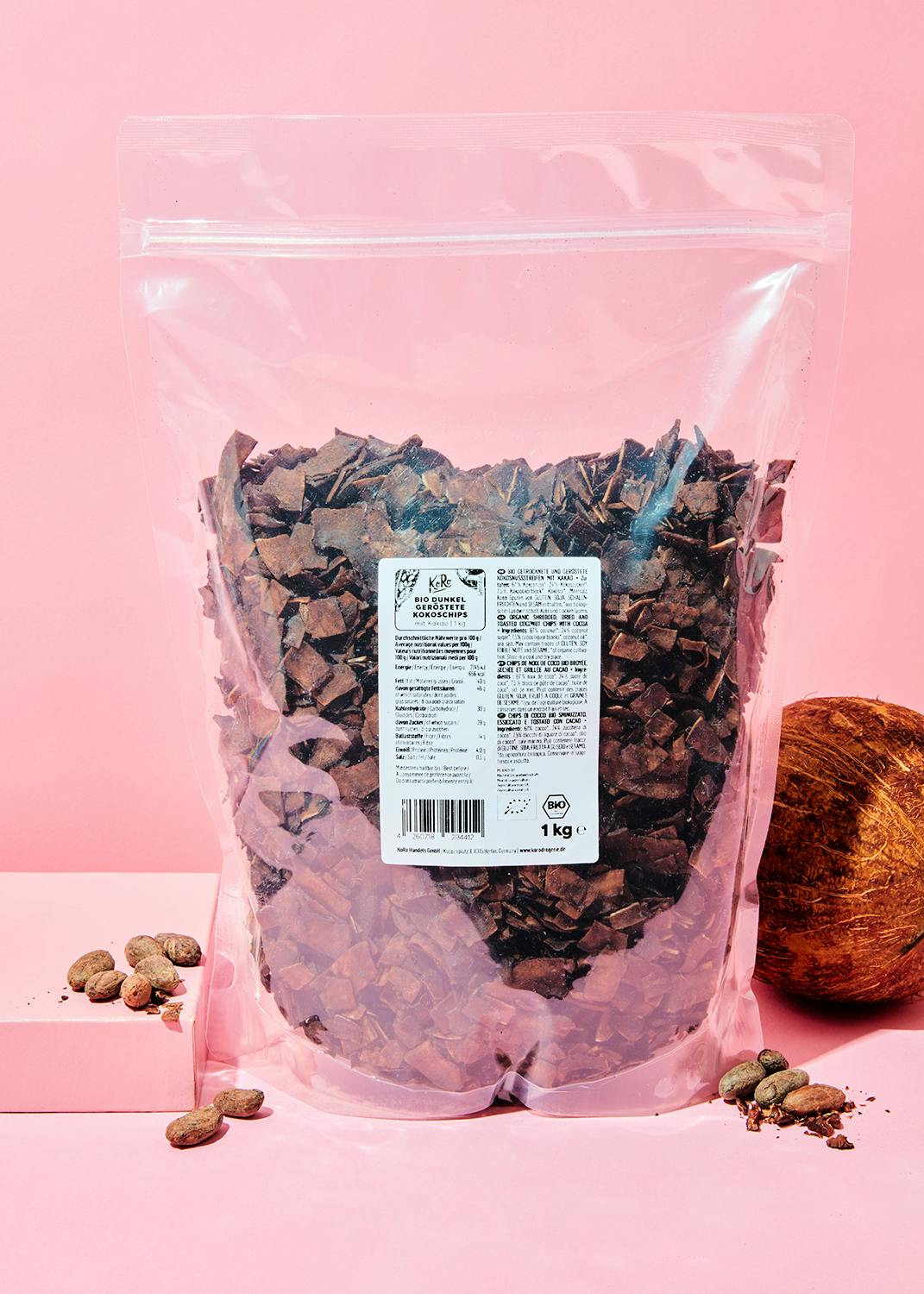 ein Plastikbeutel mit Schokoladenstücken steht auf einem rosa Tisch