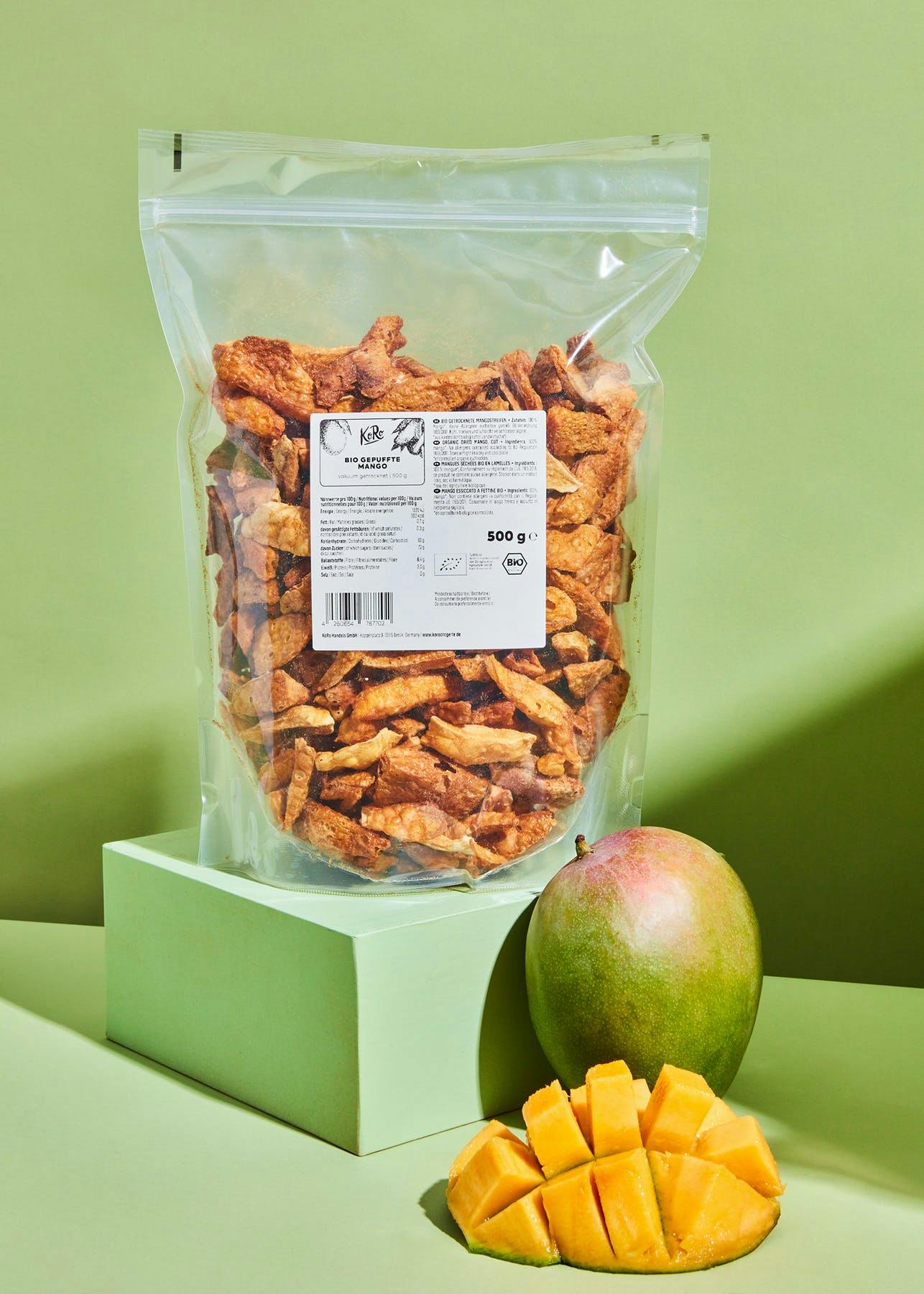 eine Tüte getrockneter Banane steht neben einer geschnittenen Banane