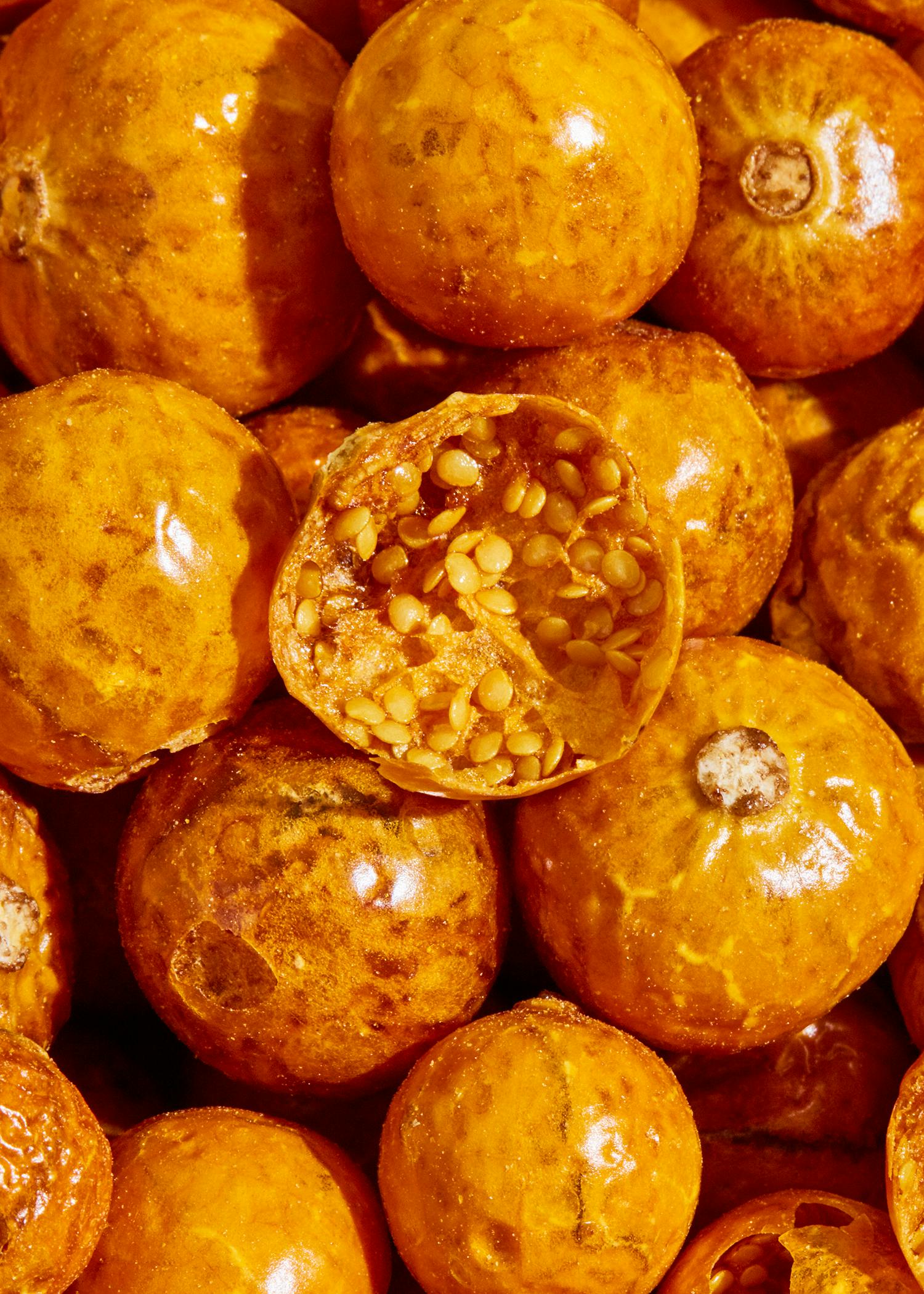 eine Nahaufnahme von einem Haufen Orangen mit einer halbierten Orange darauf