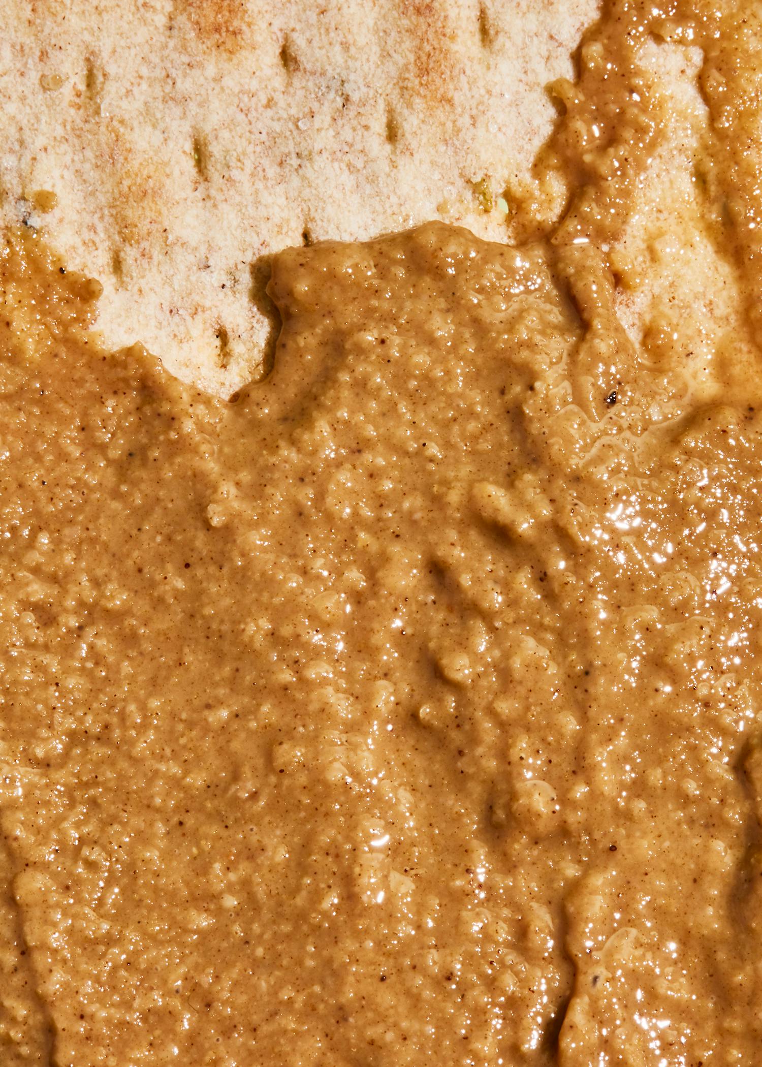 eine Nahaufnahme von Erdnussbutter auf einem Brotstück