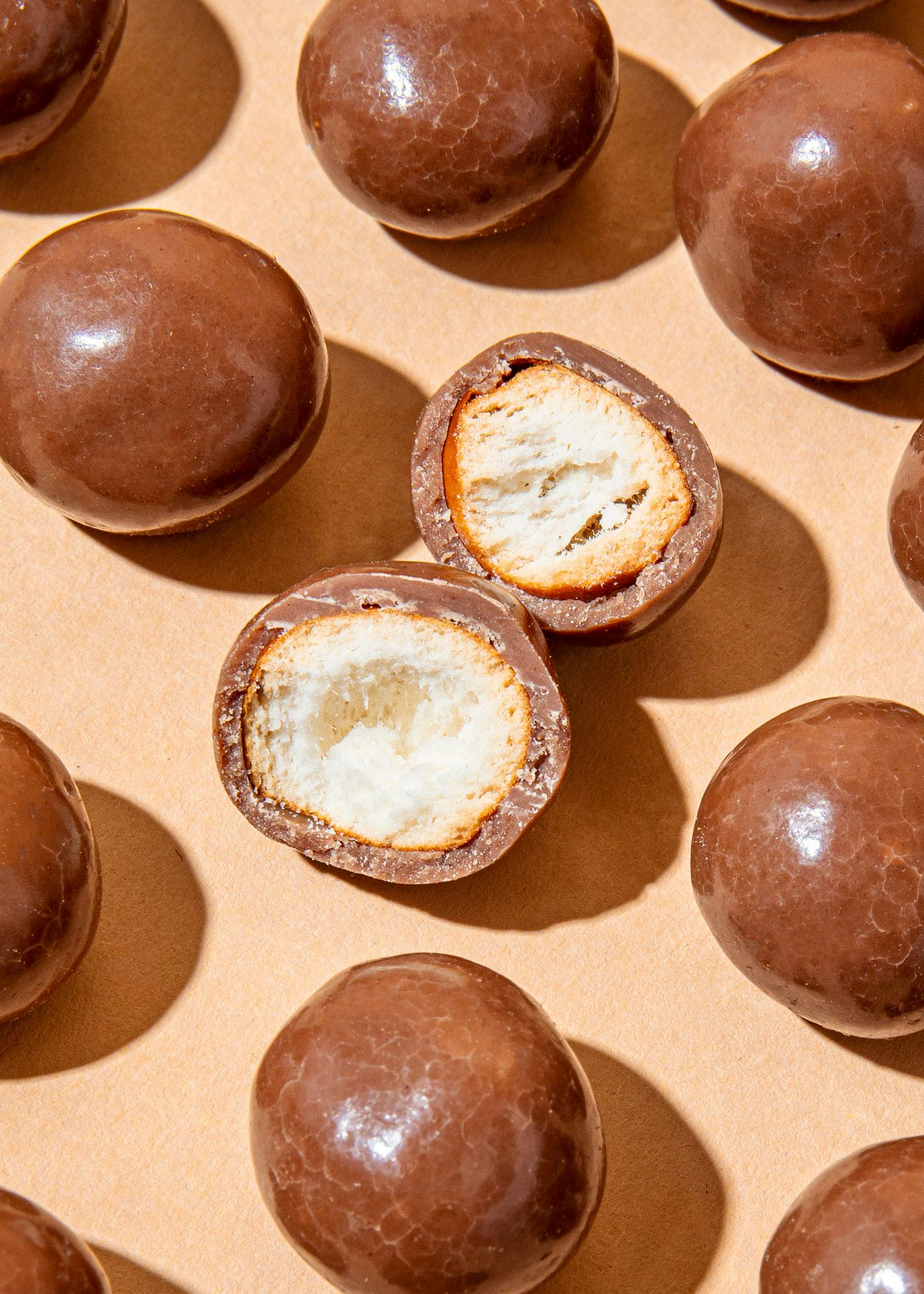 eine Nahaufnahme von Schokoladenbonbons mit einem Stück herausgenommen
