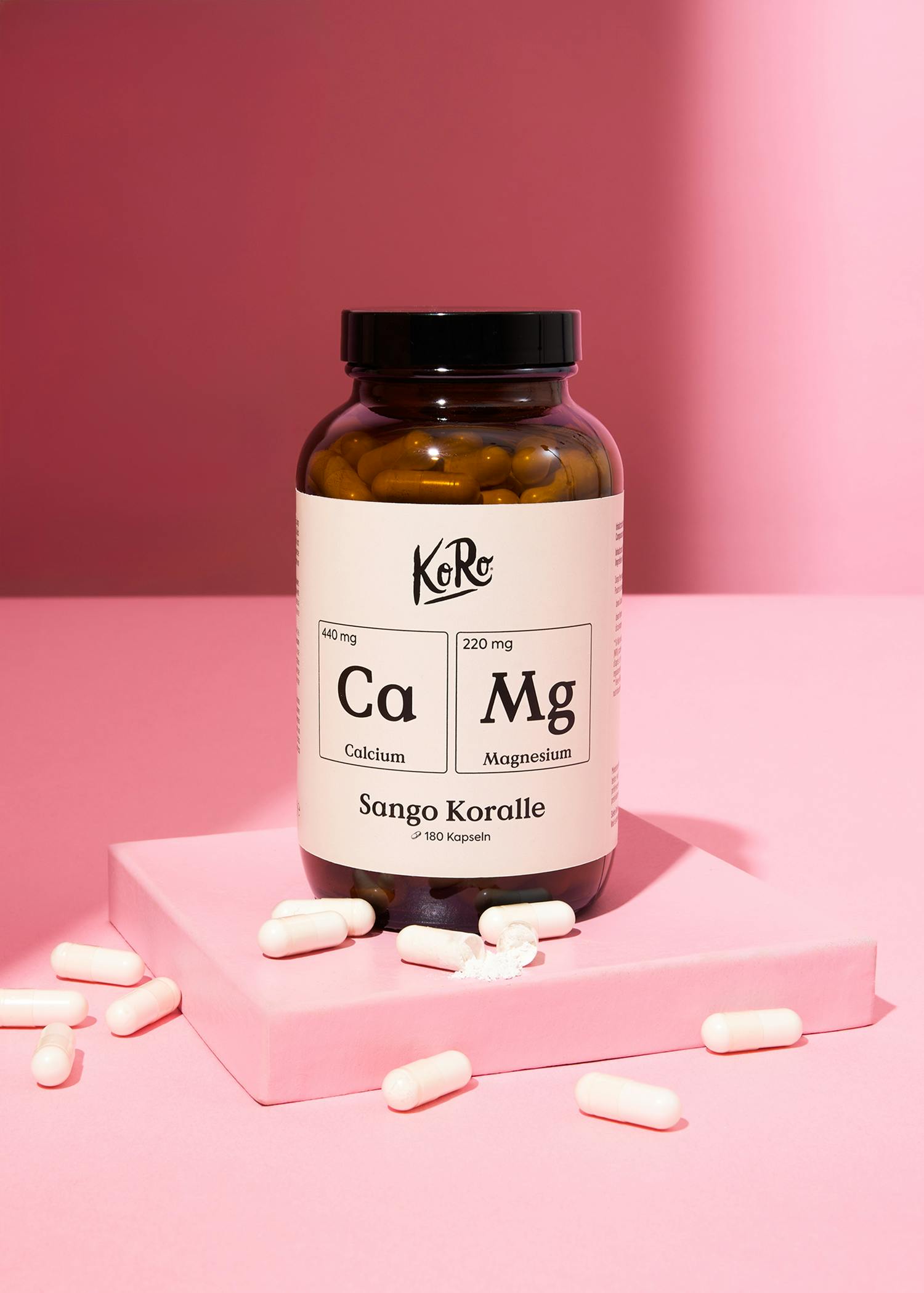 eine Flasche mit calcium und magnesium steht auf einem rosa Sockel