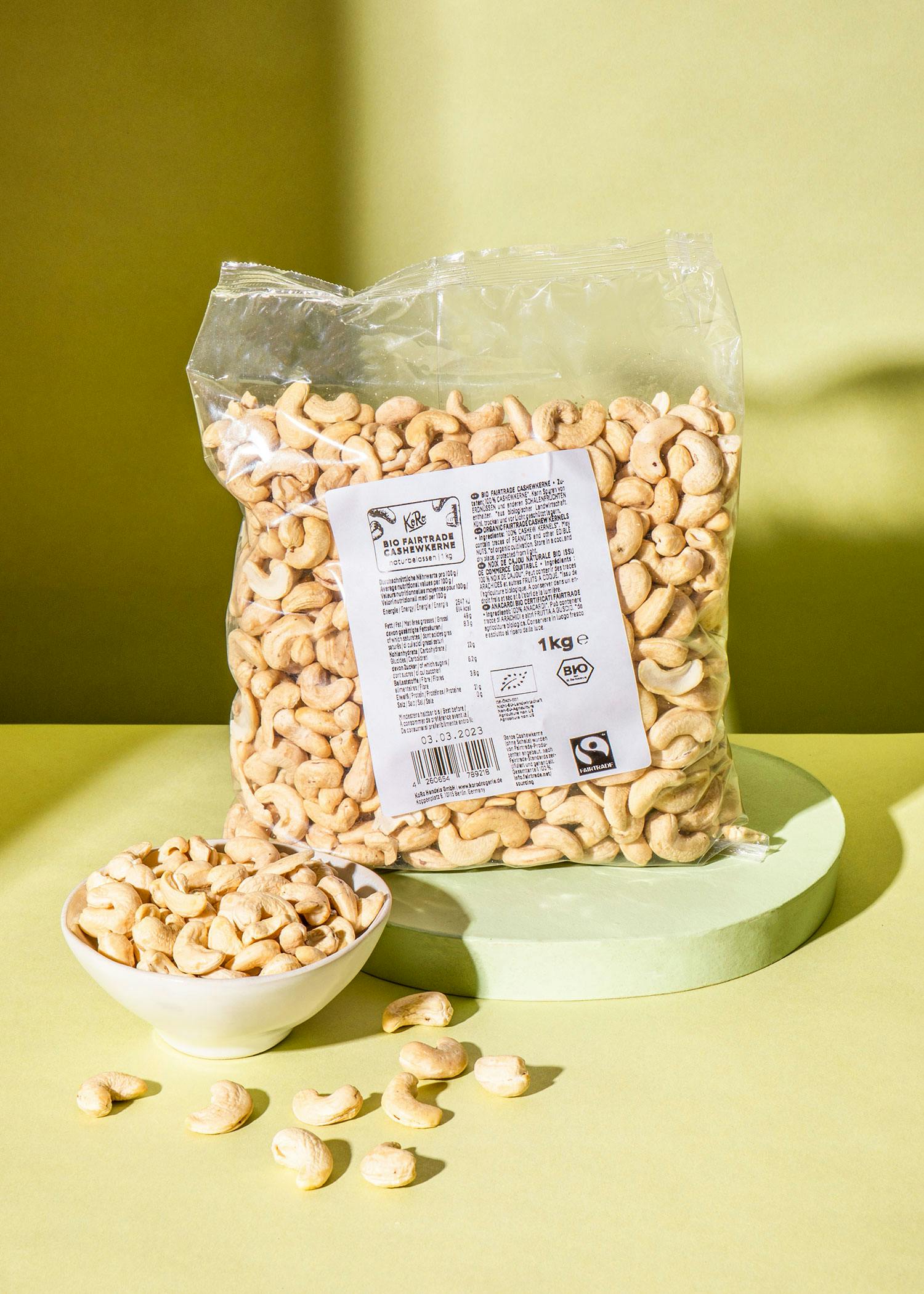 Eine Tüte Cashewnüsse steht neben einer Schüssel mit Cashewnüssen