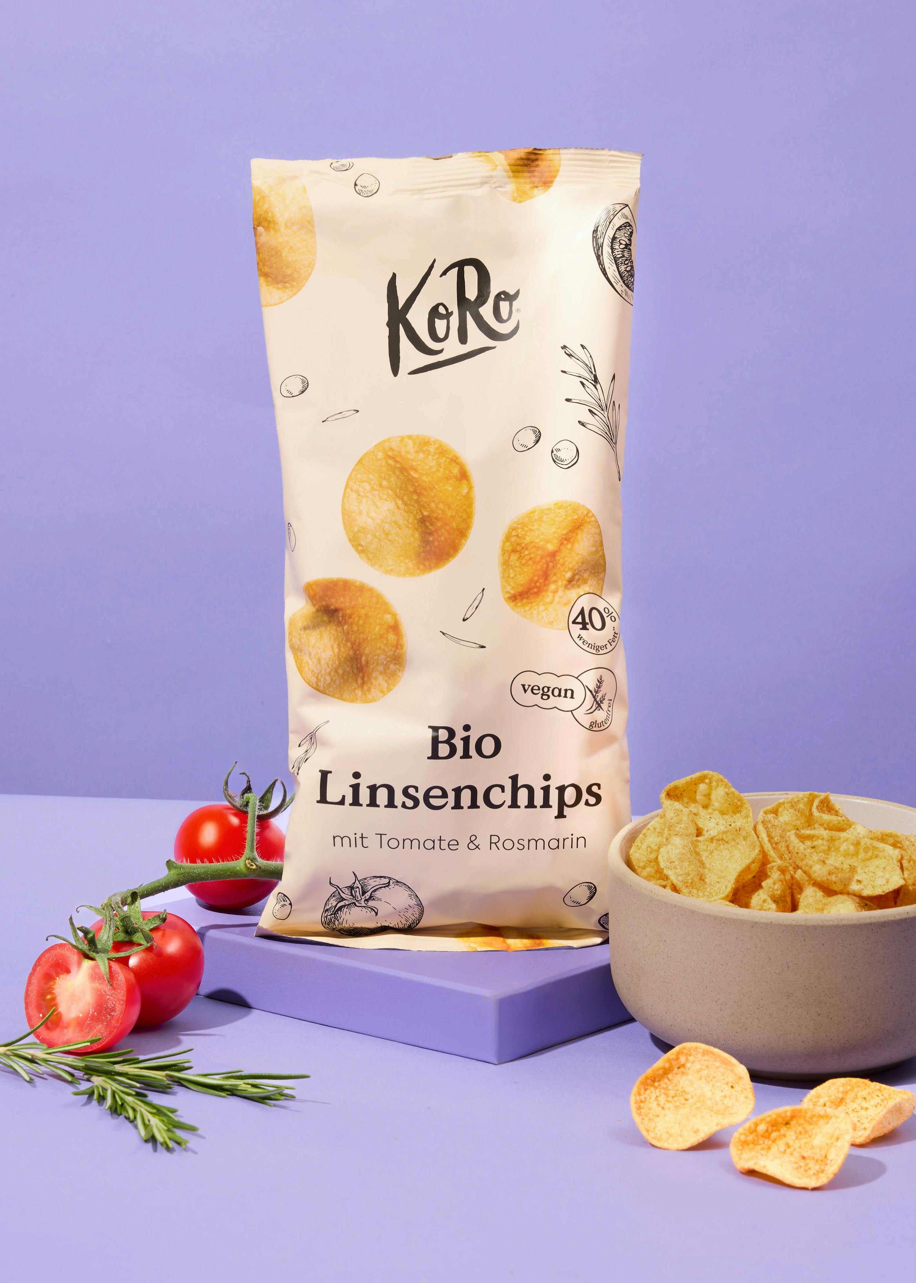 eine Tüte bio Linsenchips mit Tomaten und Rosmarin neben einer Schüssel mit Linsenchips