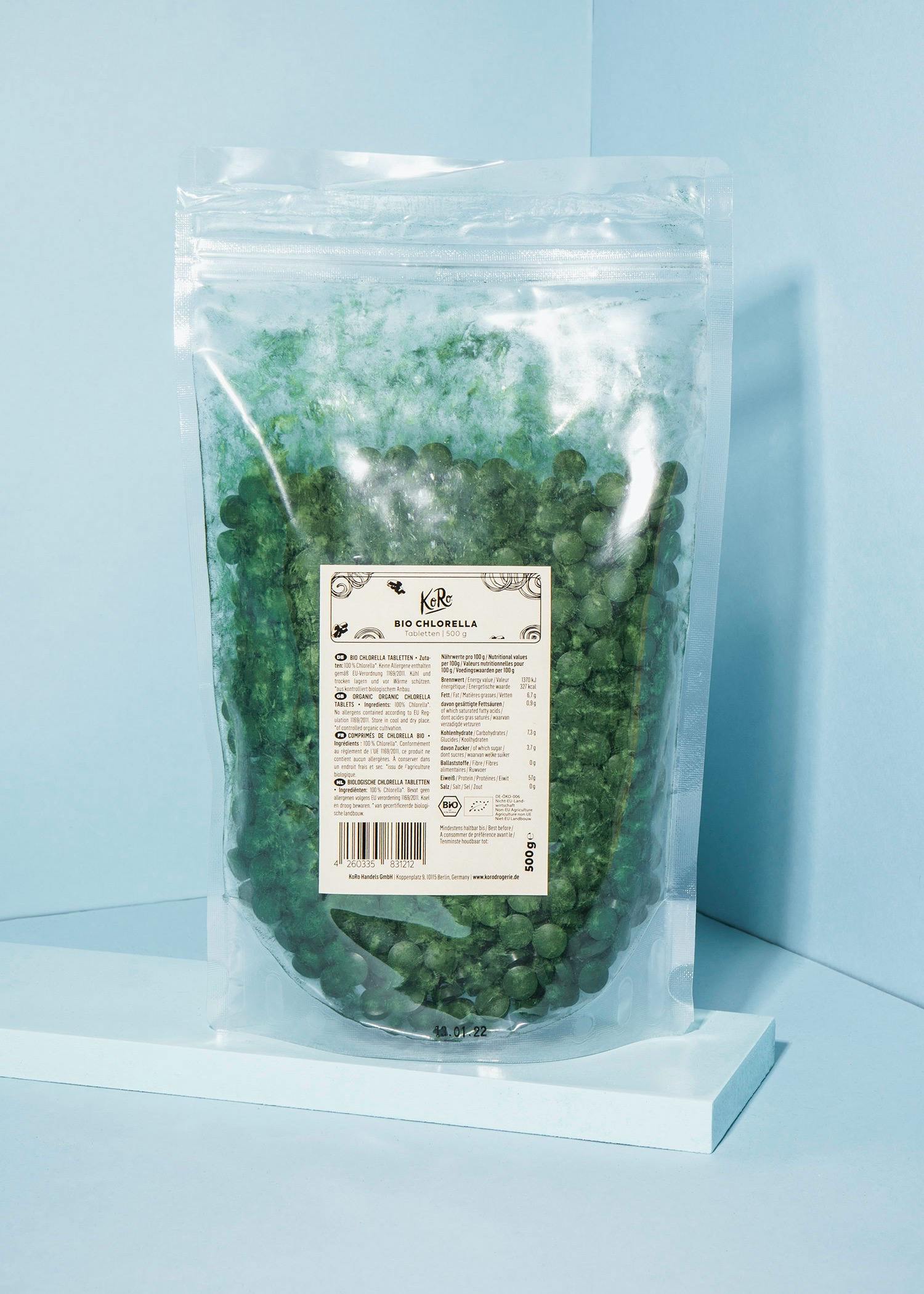 eine Plastiktüte mit grünen Perlen steht auf einem blauen Tisch