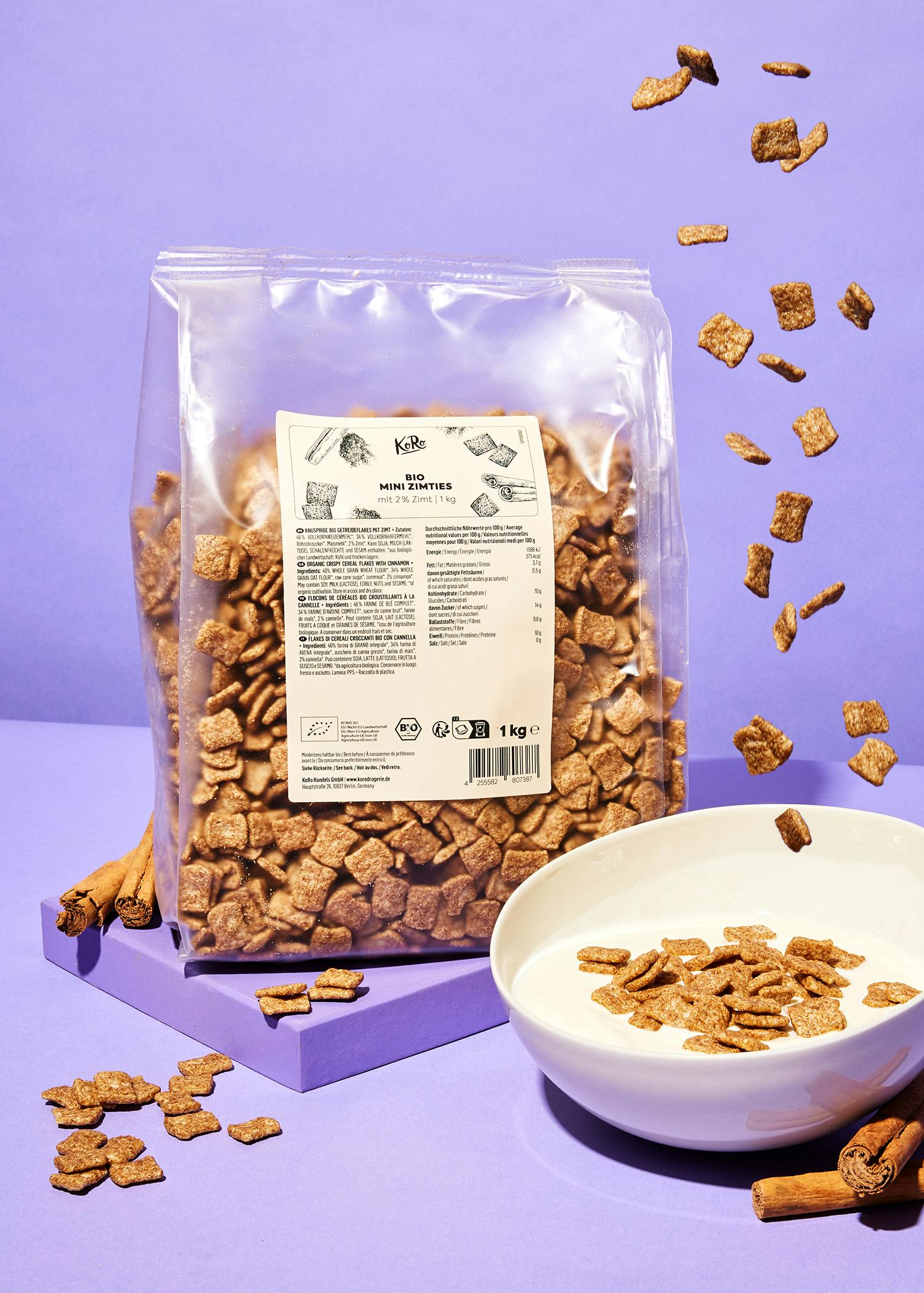 eine Tüte Mini-Crunchies steht neben einem weißen Teller mit Milch