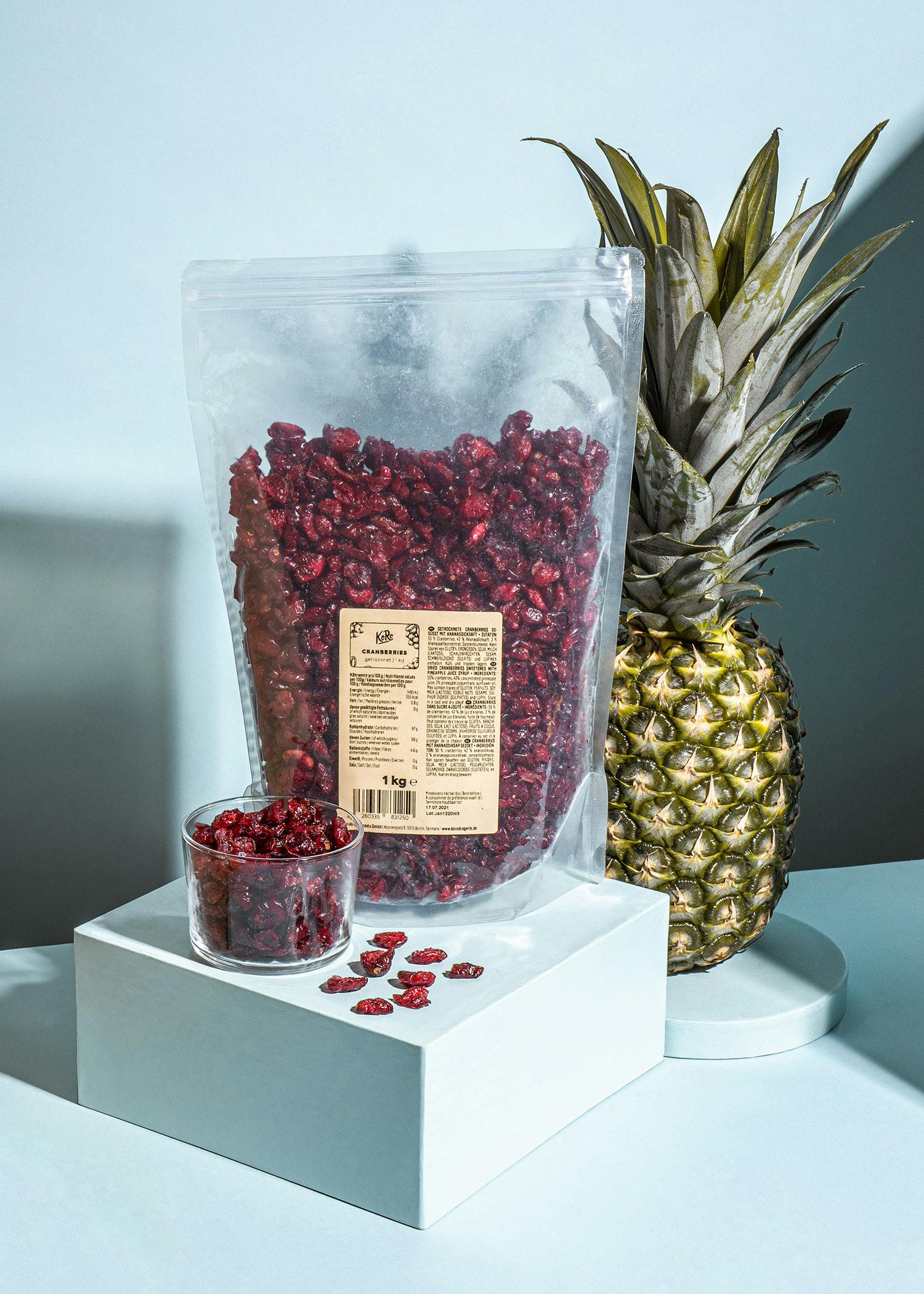 eine kleine Schüssel mit getrockneten Preiselbeeren steht neben einem großen Plastikbeutel mit Preiselbeeren