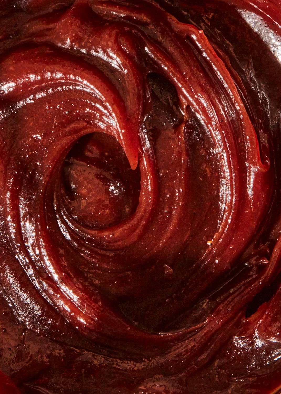 eine Nahaufnahme einer roten Soße mit einem Swirl in der Mitte