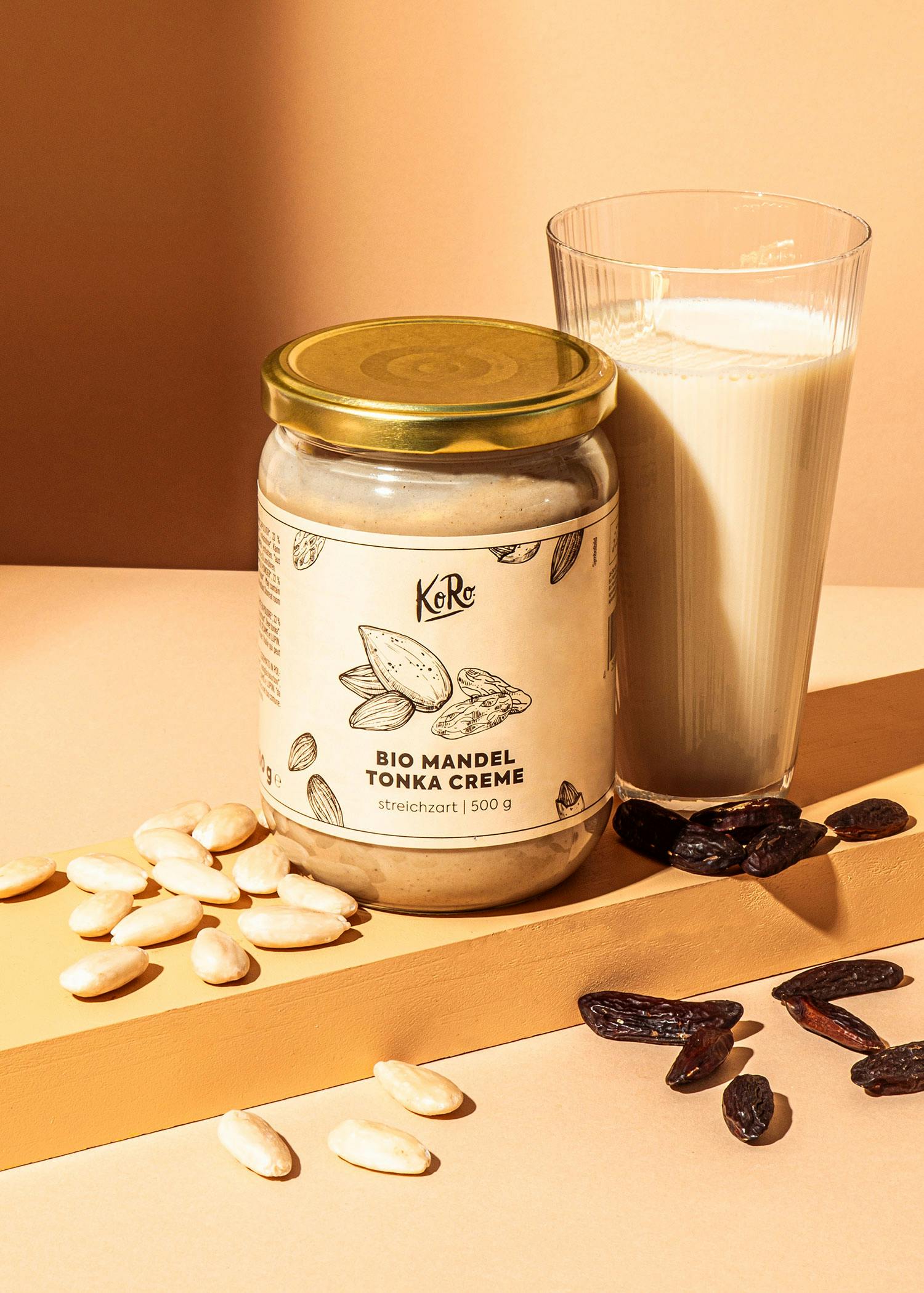 ein Glas Bio-Mandel-Tonka-Creme steht neben einem Glas Milch