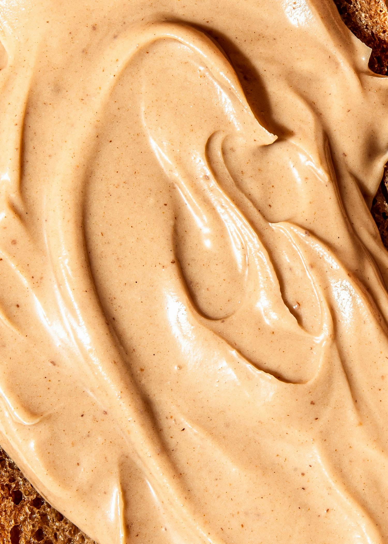 eine Nahaufnahme einer Erdnussbutter auf einem Stück Brot