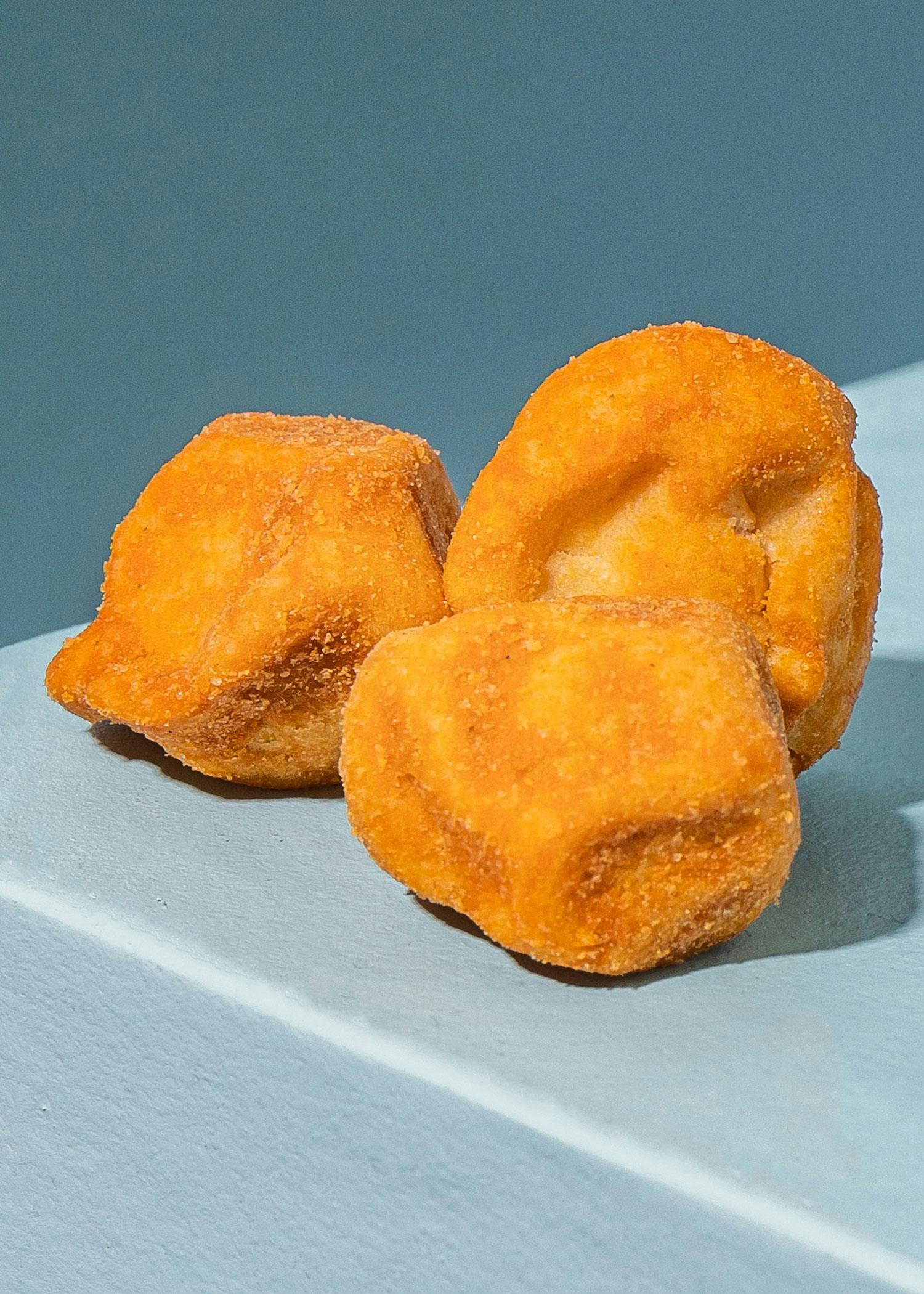 drei gebackene Donuts sitzen auf einem Tisch