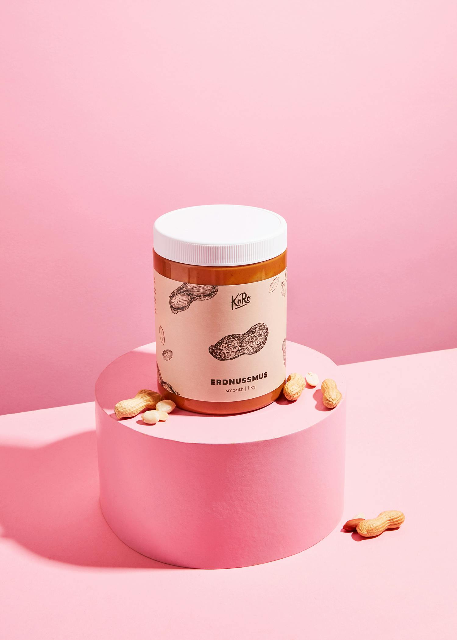 eine Dose Erdnussmus steht auf einem rosa Sockel