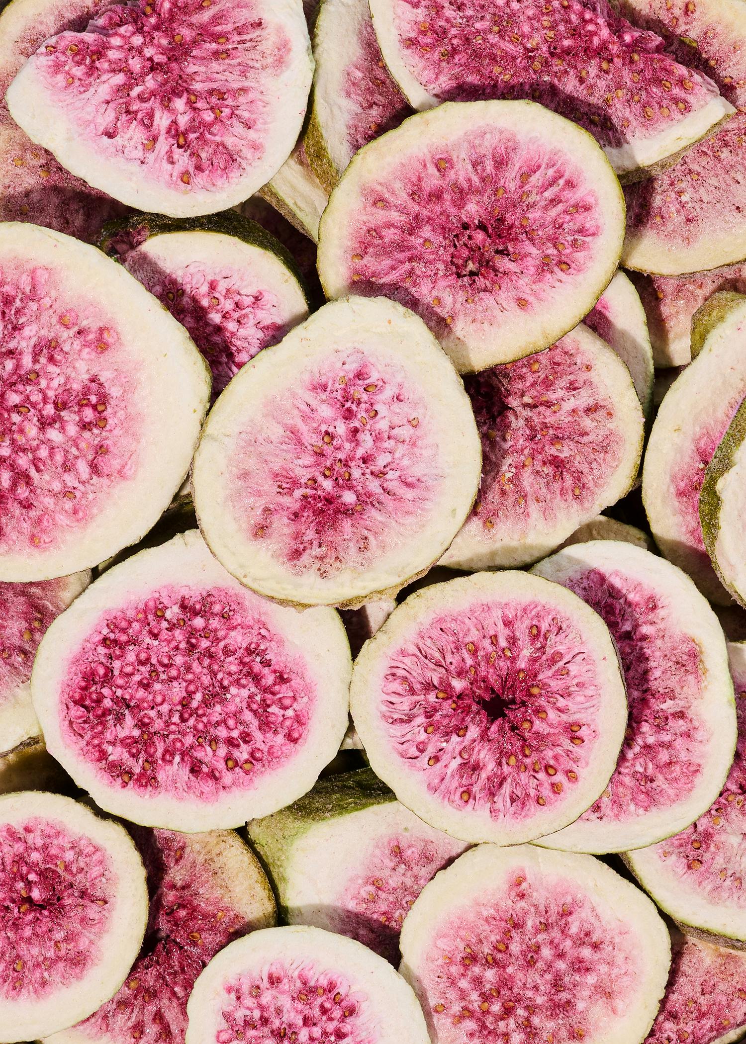ein Haufen geschnittener Früchte mit rosa Samen