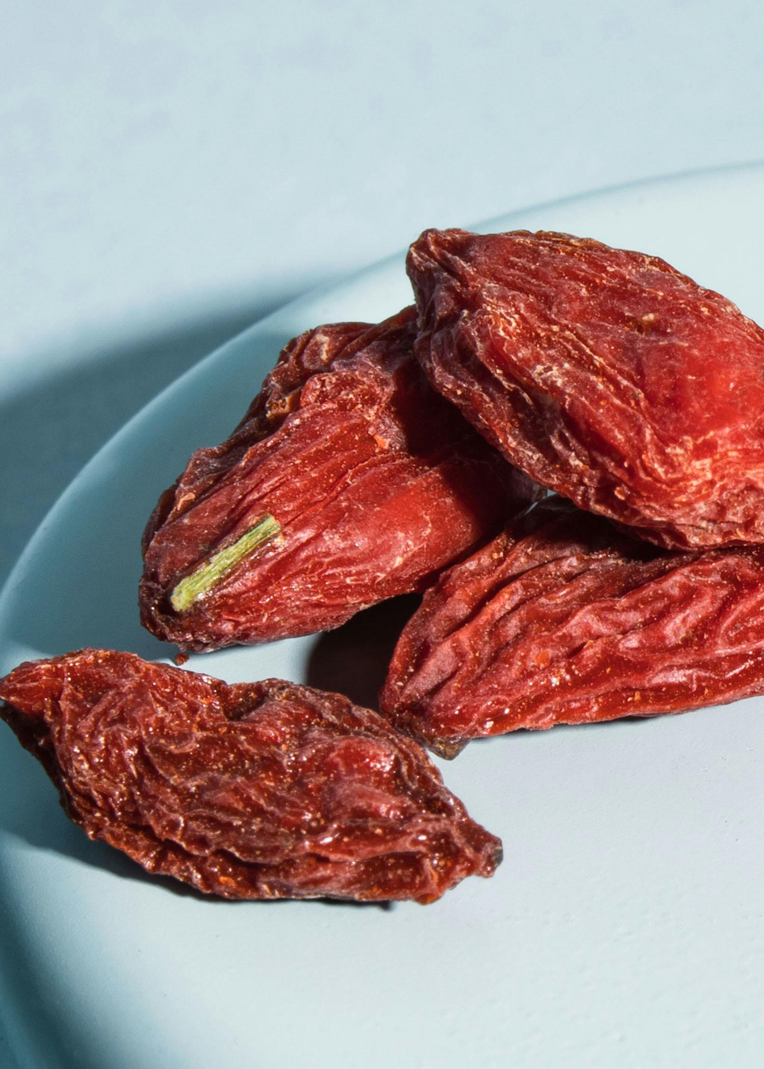 ein weißer Teller mit roten Tomaten auf einem Tisch