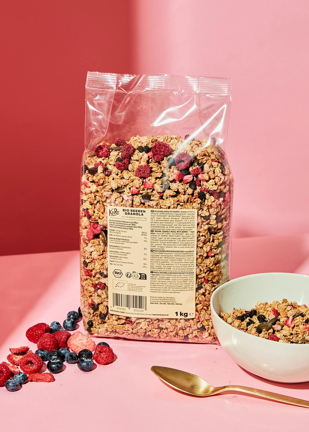 eine Packung Granola mit Beeren neben einer Schüssel Granola