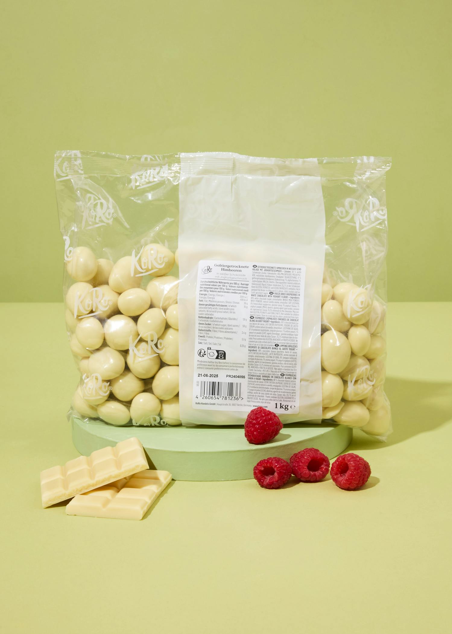 eine Tüte weißer Schokolade mit Himbeeren neben ihr