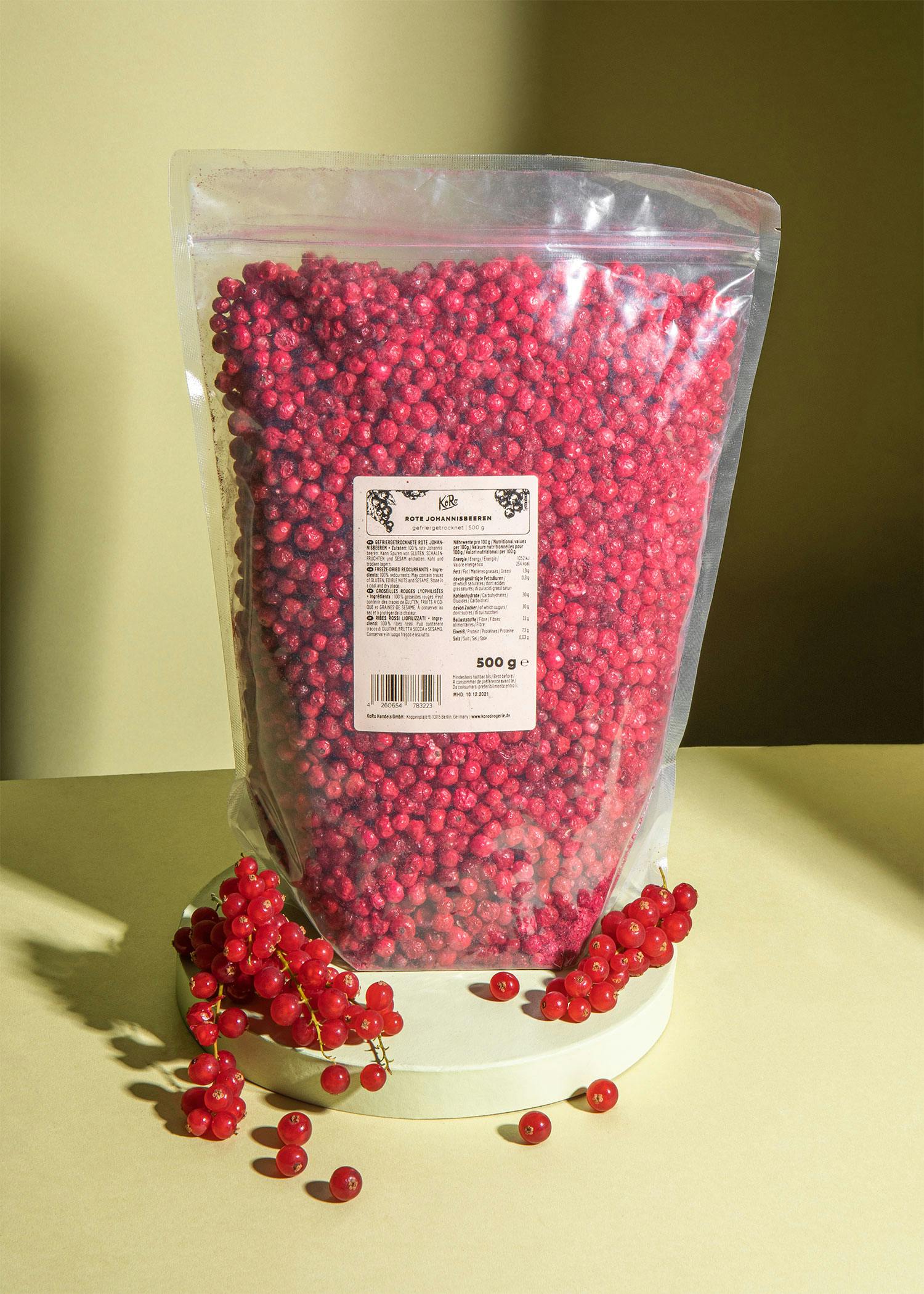 Eine Plastiktüte mit roten Beeren steht auf einem Tisch