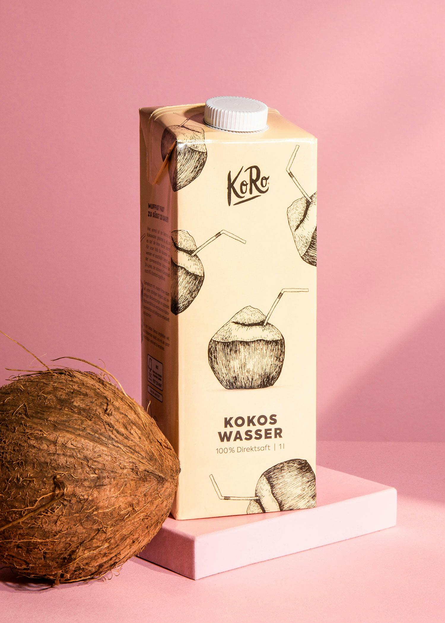 Eine Flasche Kokoswasser steht neben einer Kokosnuss