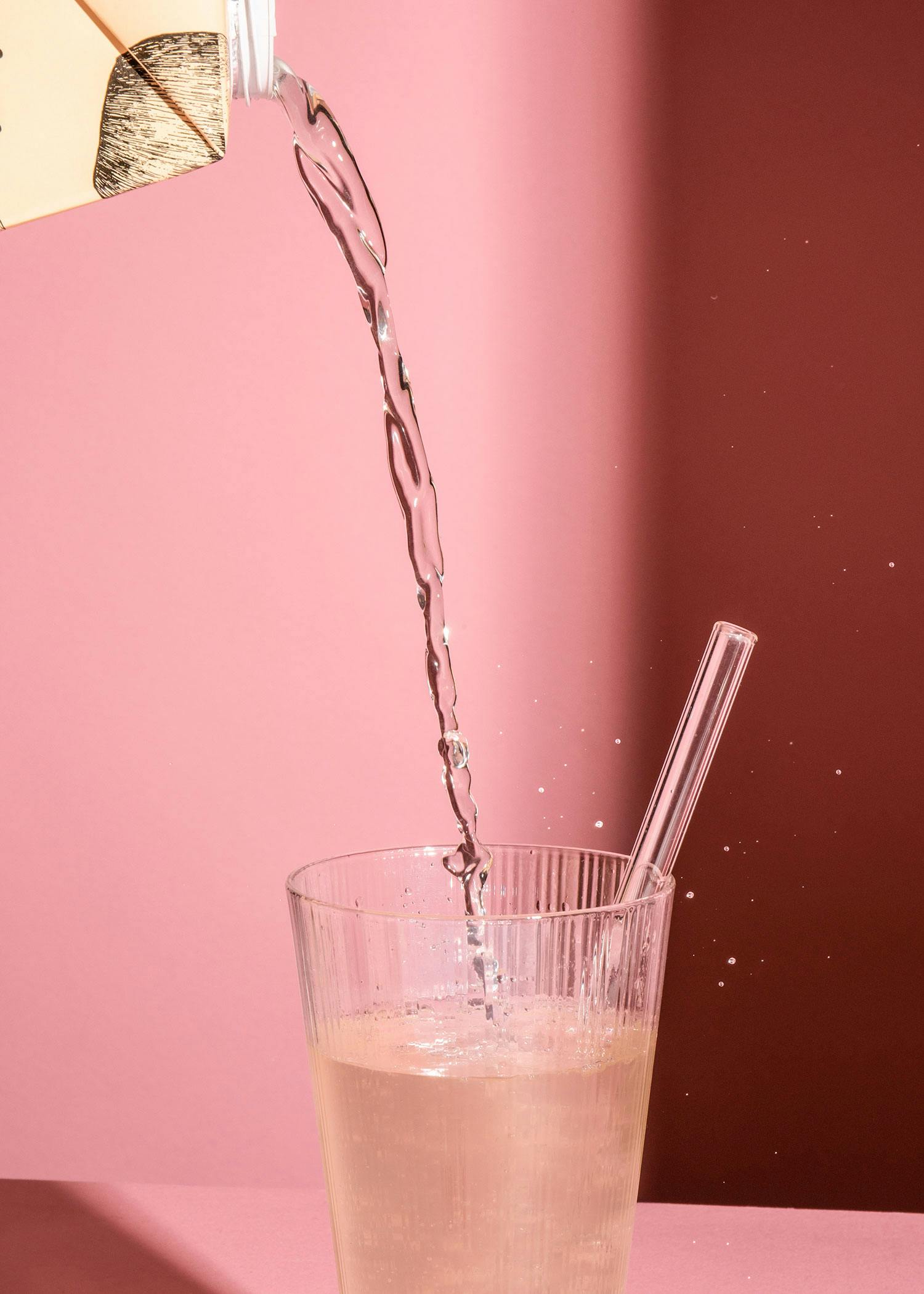 Wasser wird aus einer Flasche in ein Glas gegossen