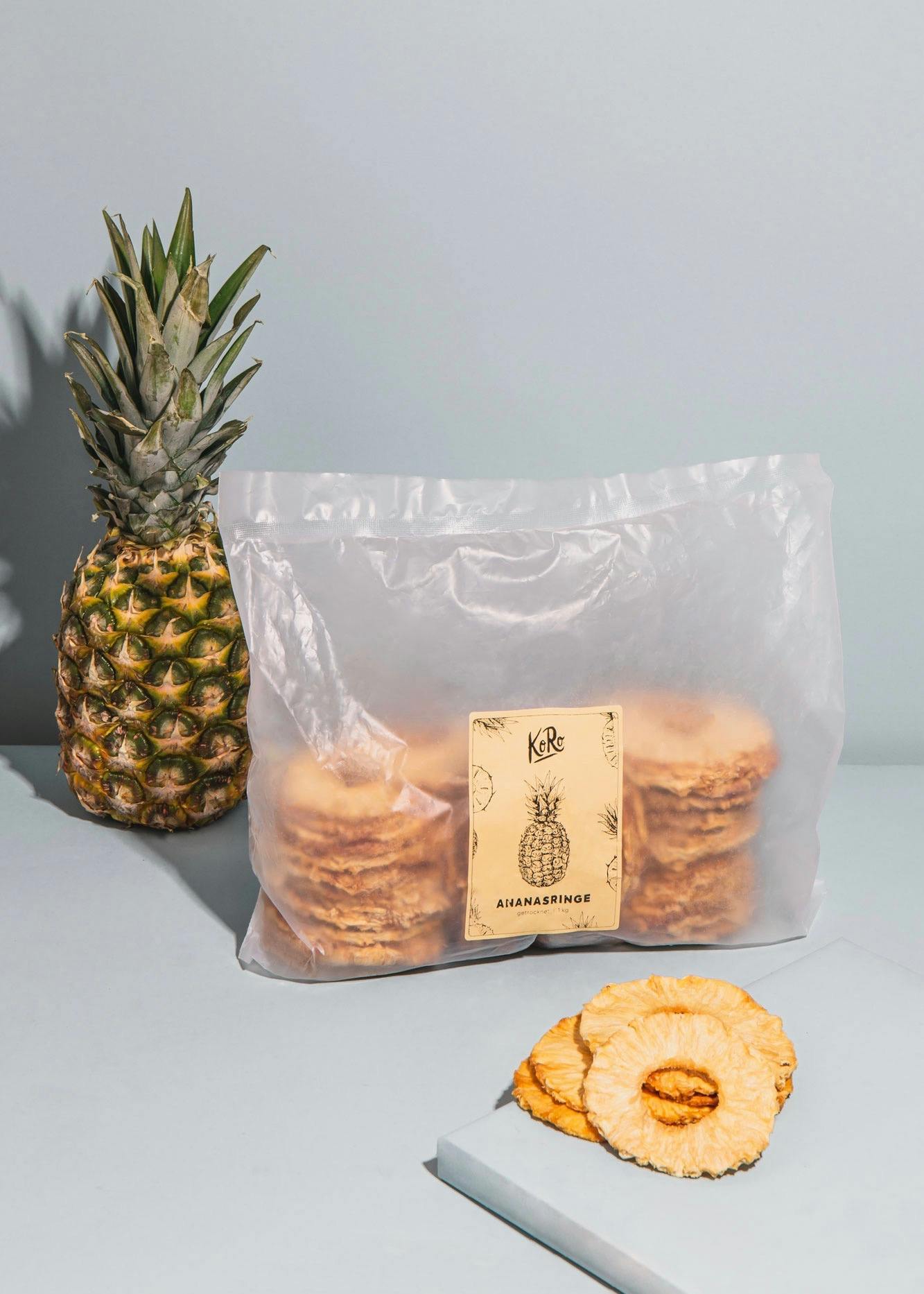ein Plastikbeutel mit Ananasringe steht neben einer Ananas