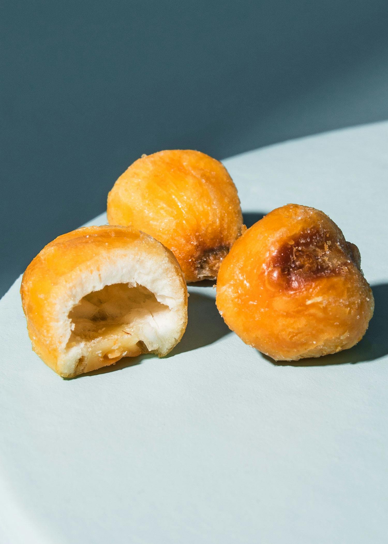 drei Donuts auf einem Teller mit einem Stück genommen