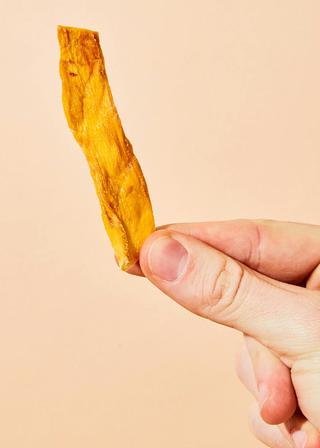 eine Person hält einen Stück getrockneten Obst in der Hand