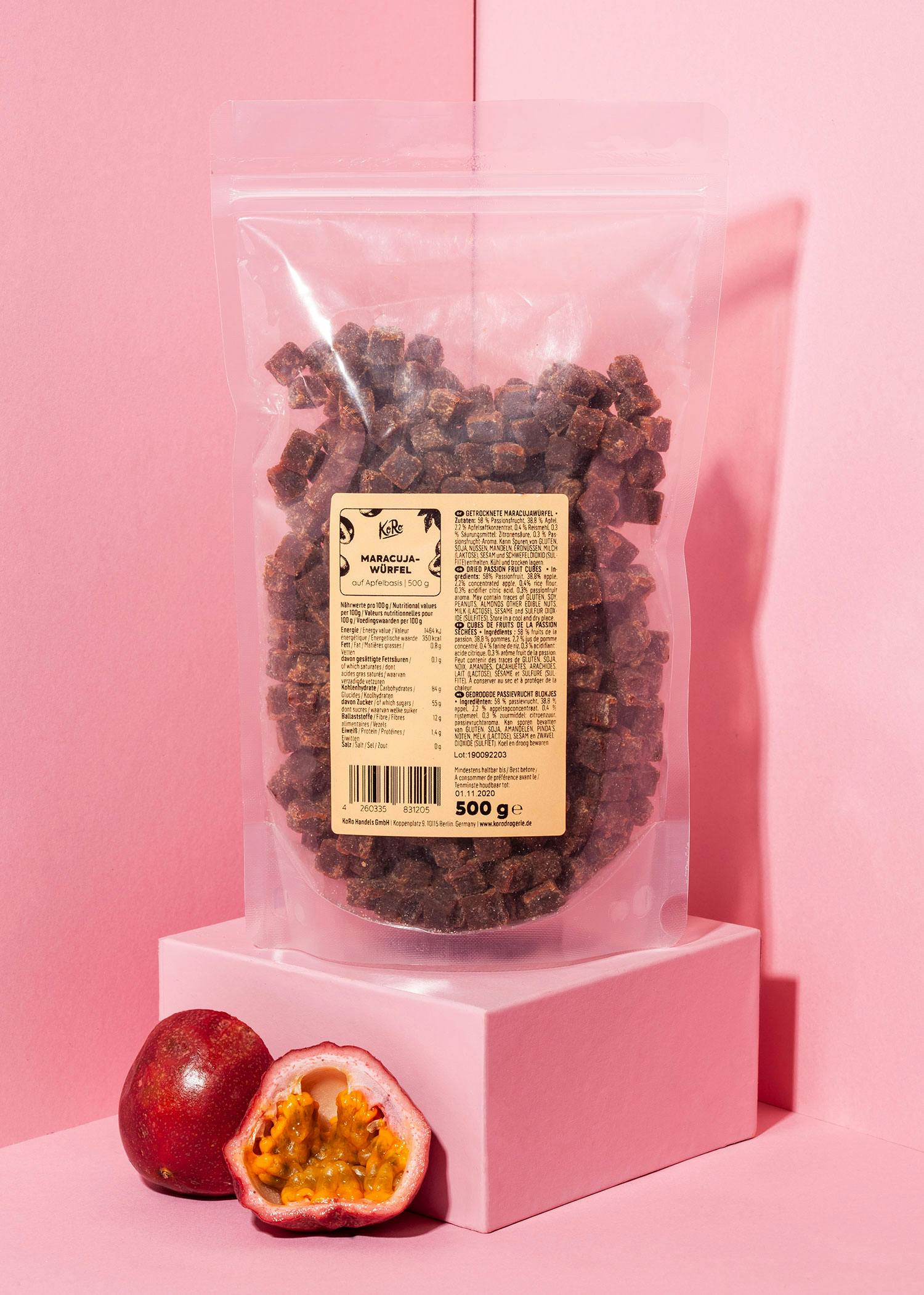 ein beutel mit einem etikett steht auf einem rosa würfel neben einer passionsfrucht