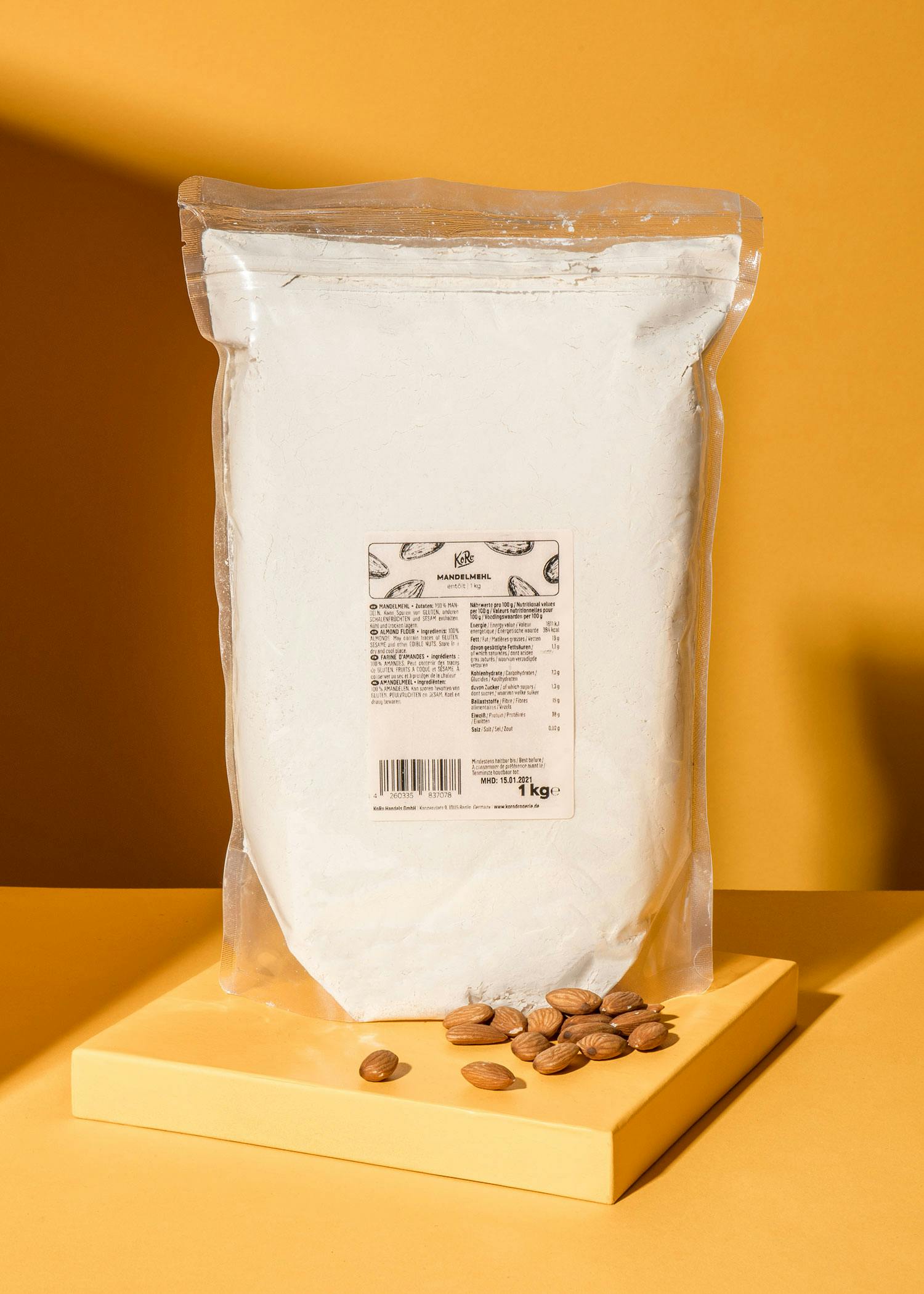 eine Plastiktüte mit einem Etikett auf der Rückseite steht auf einem Tisch neben einem Haufen Mandeln