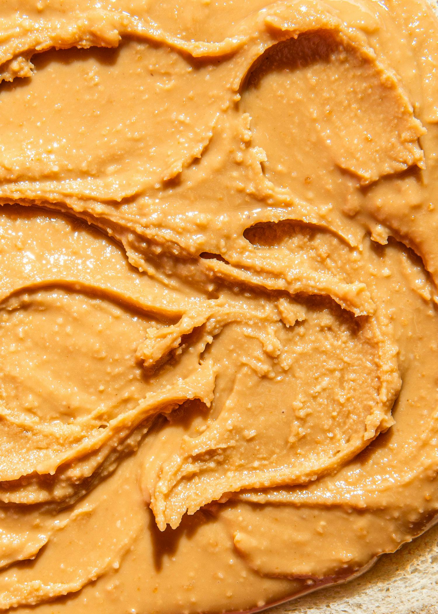 eine Nahaufnahme einer Erdnussbutter auf einem Stück Brot