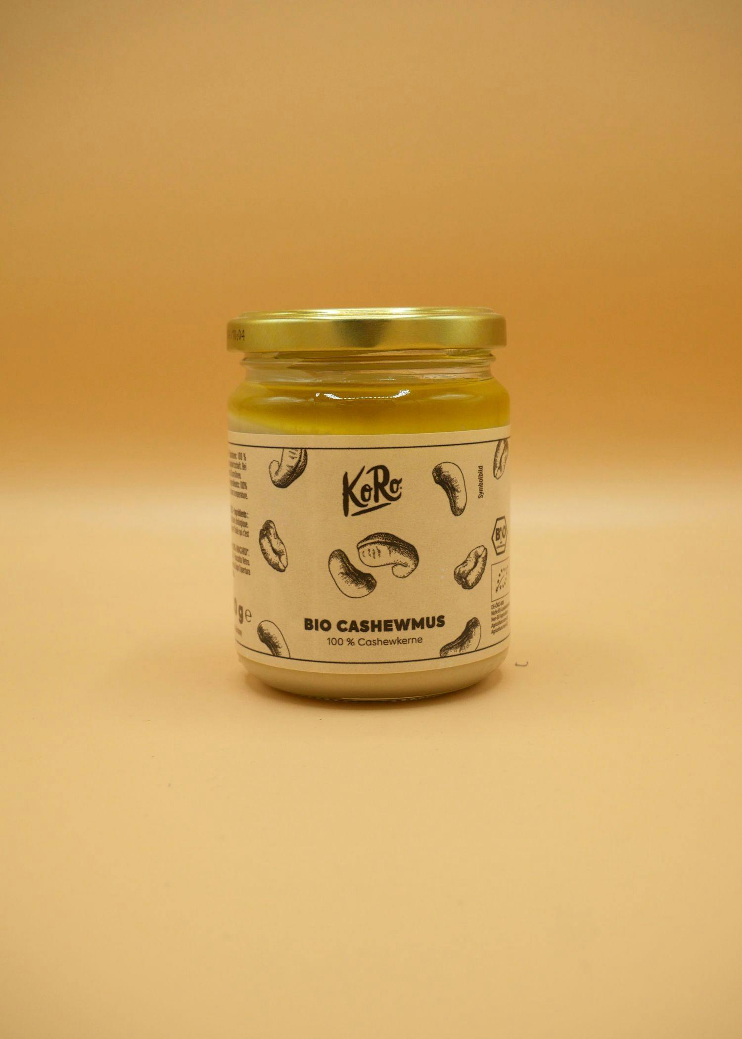 ein Glas Bio Cashewmus steht auf einem braunen Hintergrund