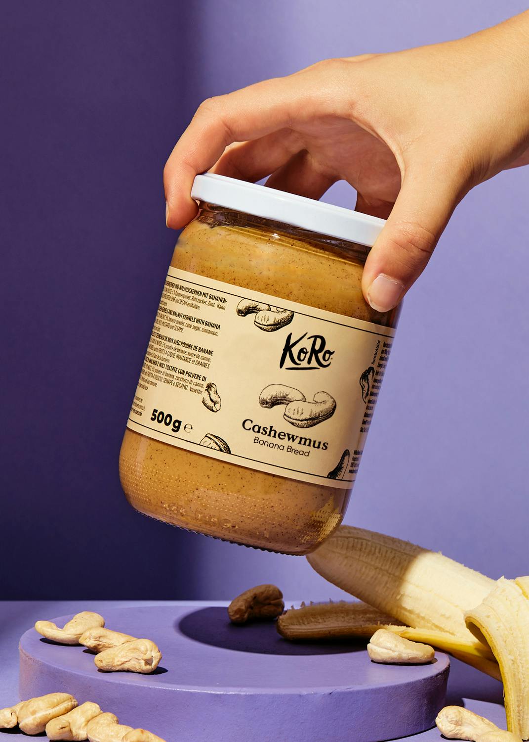 eine Person hält ein Glas cashewmus in der Hand