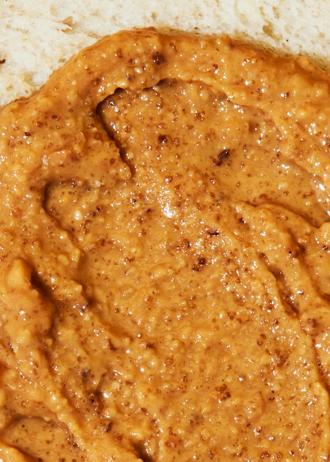 eine Nahaufnahme einer Erdnussbutter auf einem Stück Brot