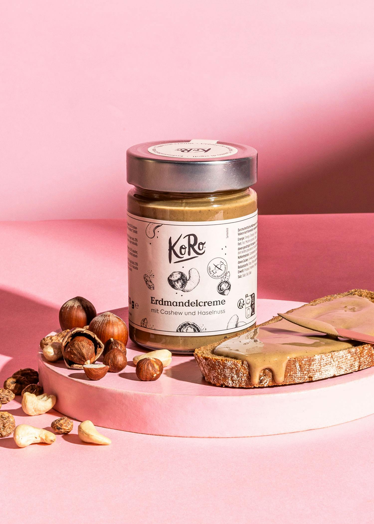 eine Dose Erdmandelcreme mit Cashew und Haselnüssen neben einem Stück Brot