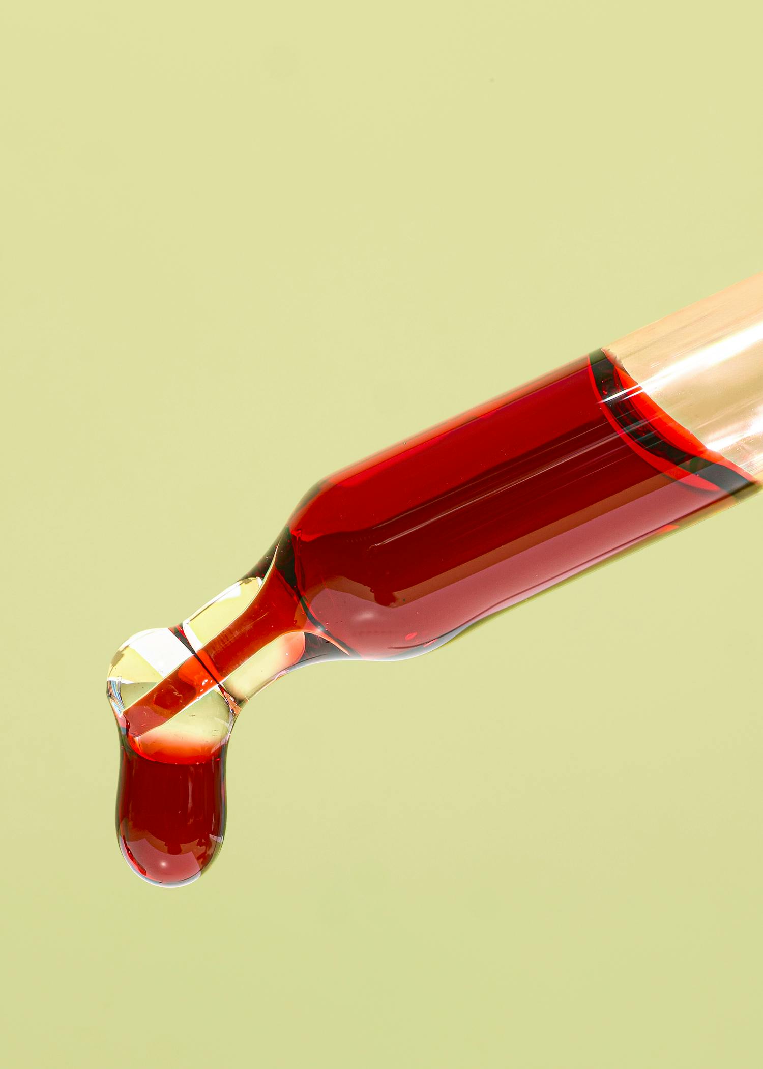 ein Tropfen roter Flüssigkeit kommt aus einer pipette