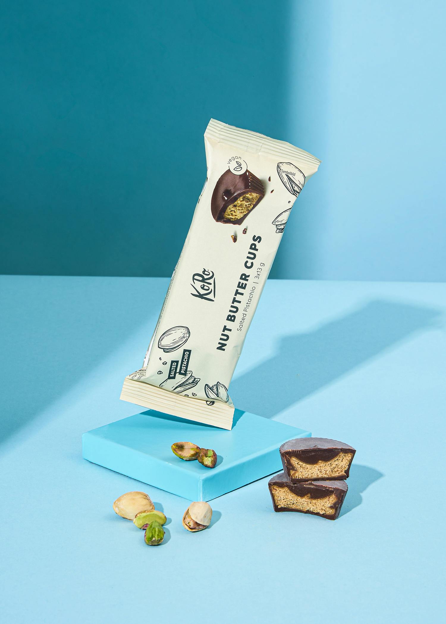 eine weiße verpackung von kakao-nussbutter-cups mit pistazien