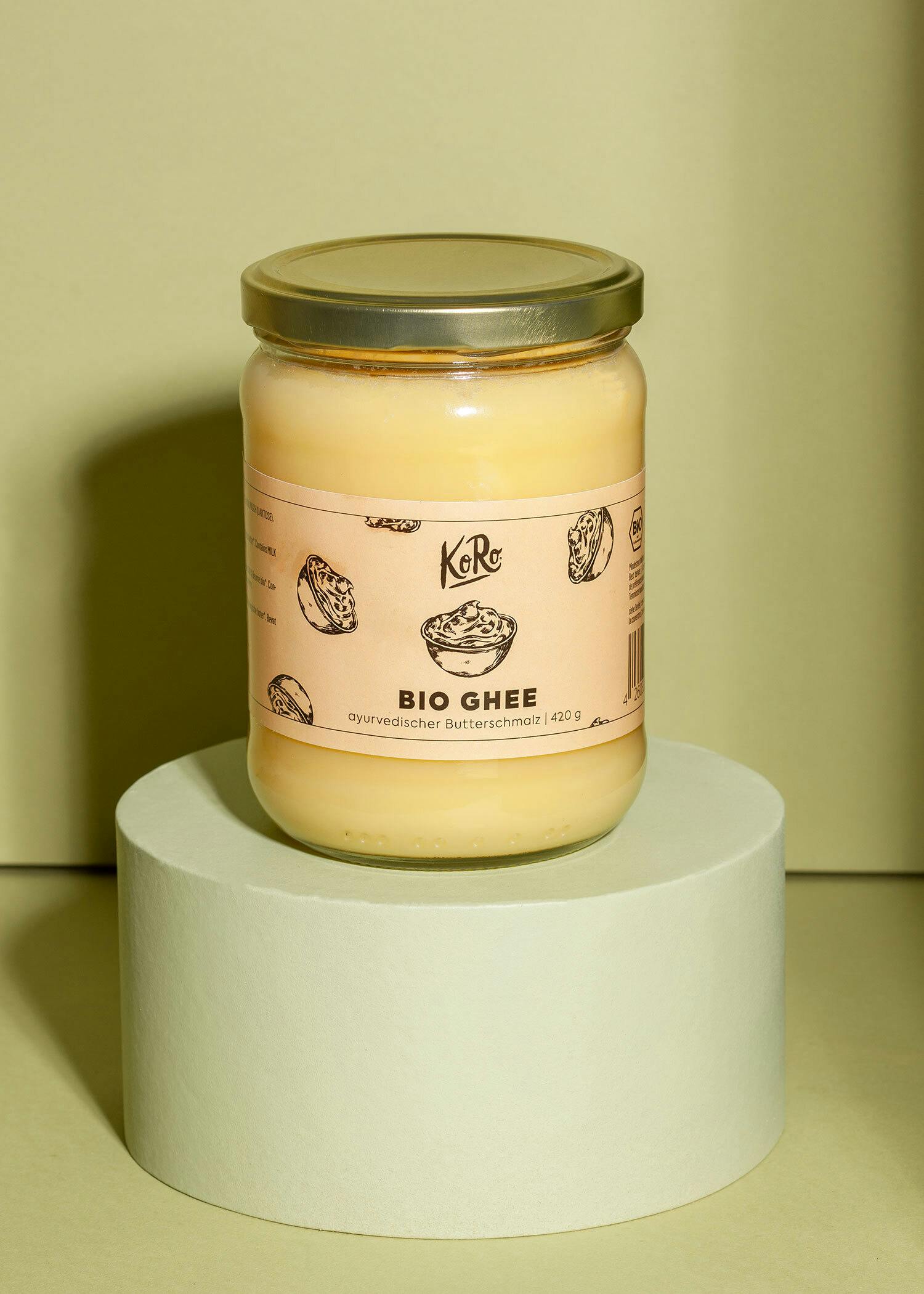 ein Glas bio ghee steht auf einem grünen Sockel