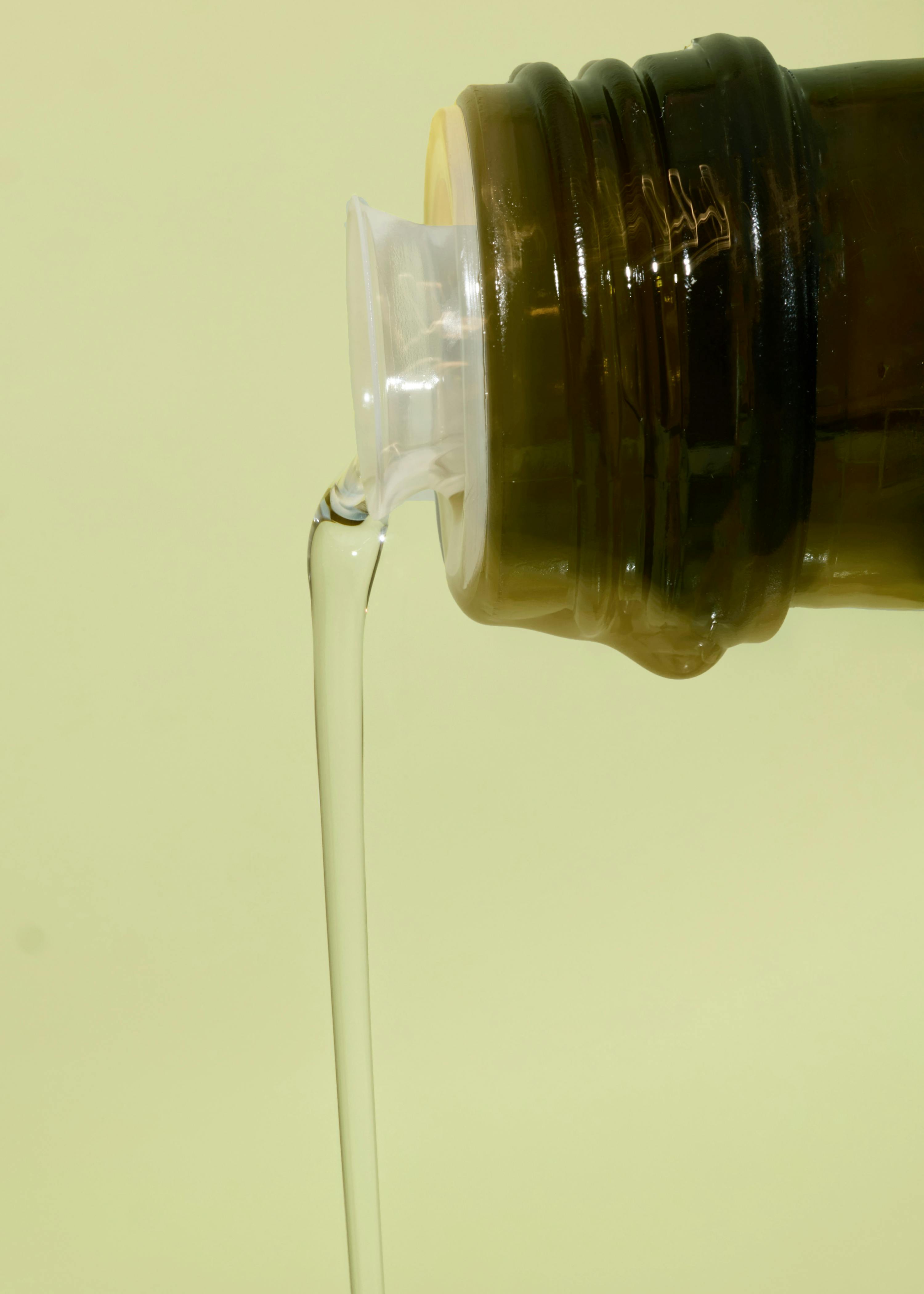 Olivenöl wird aus einer braunen Flasche gegossen
