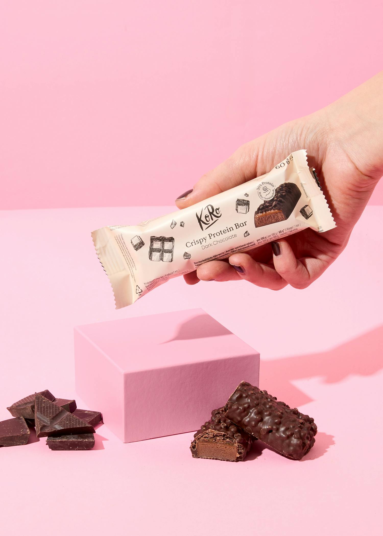 Eine Person hält eine Karamell-Schokoladenprotein-Bar in der Hand