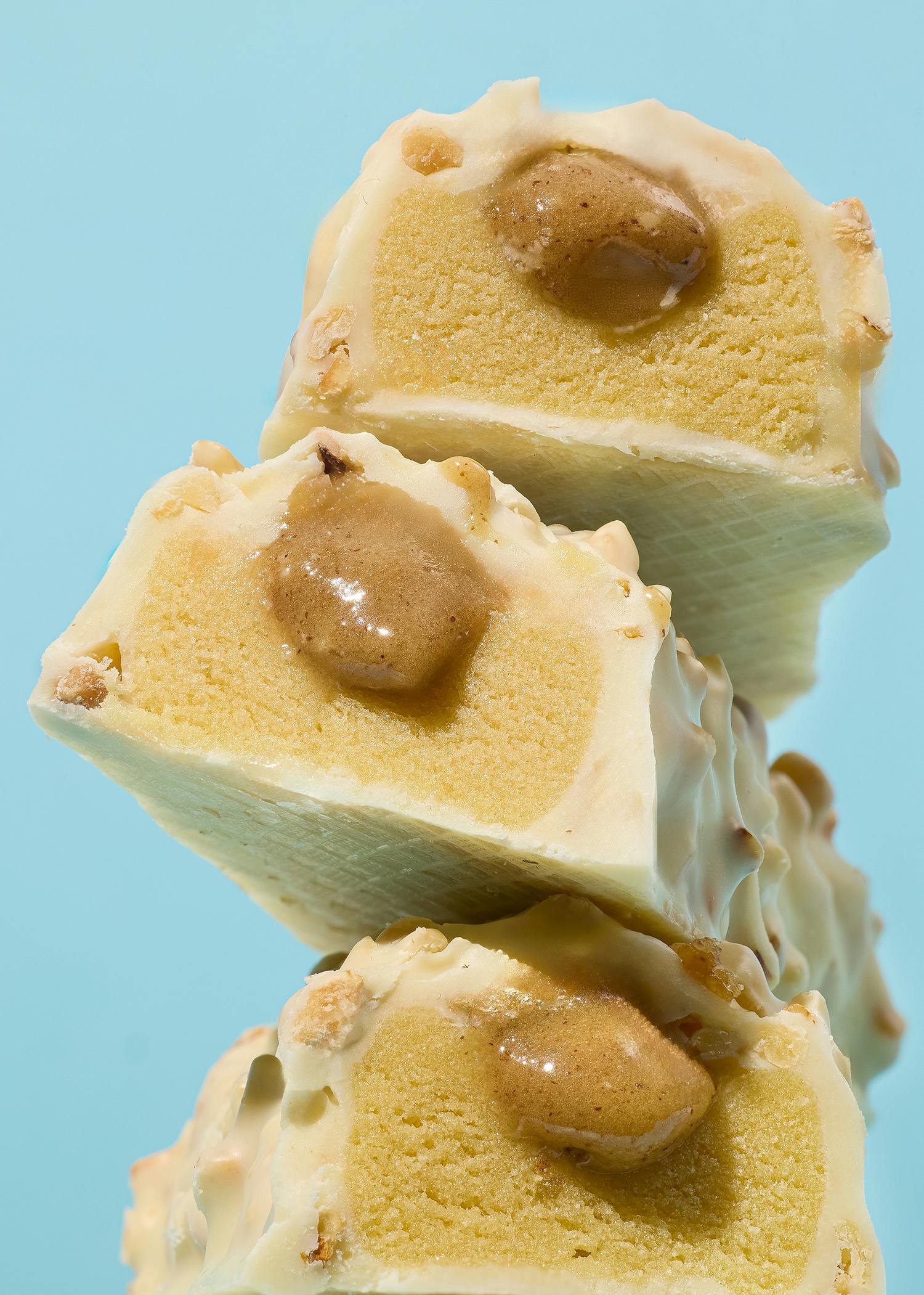 drei Kekse mit weißer Schokolade und Erdnussbutter auf einem blauen Hintergrund