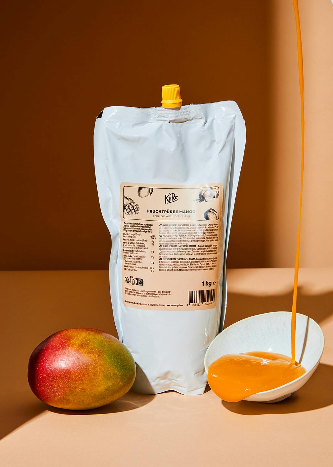 ein beutel mit fruchtpüree mango steht neben einem mango