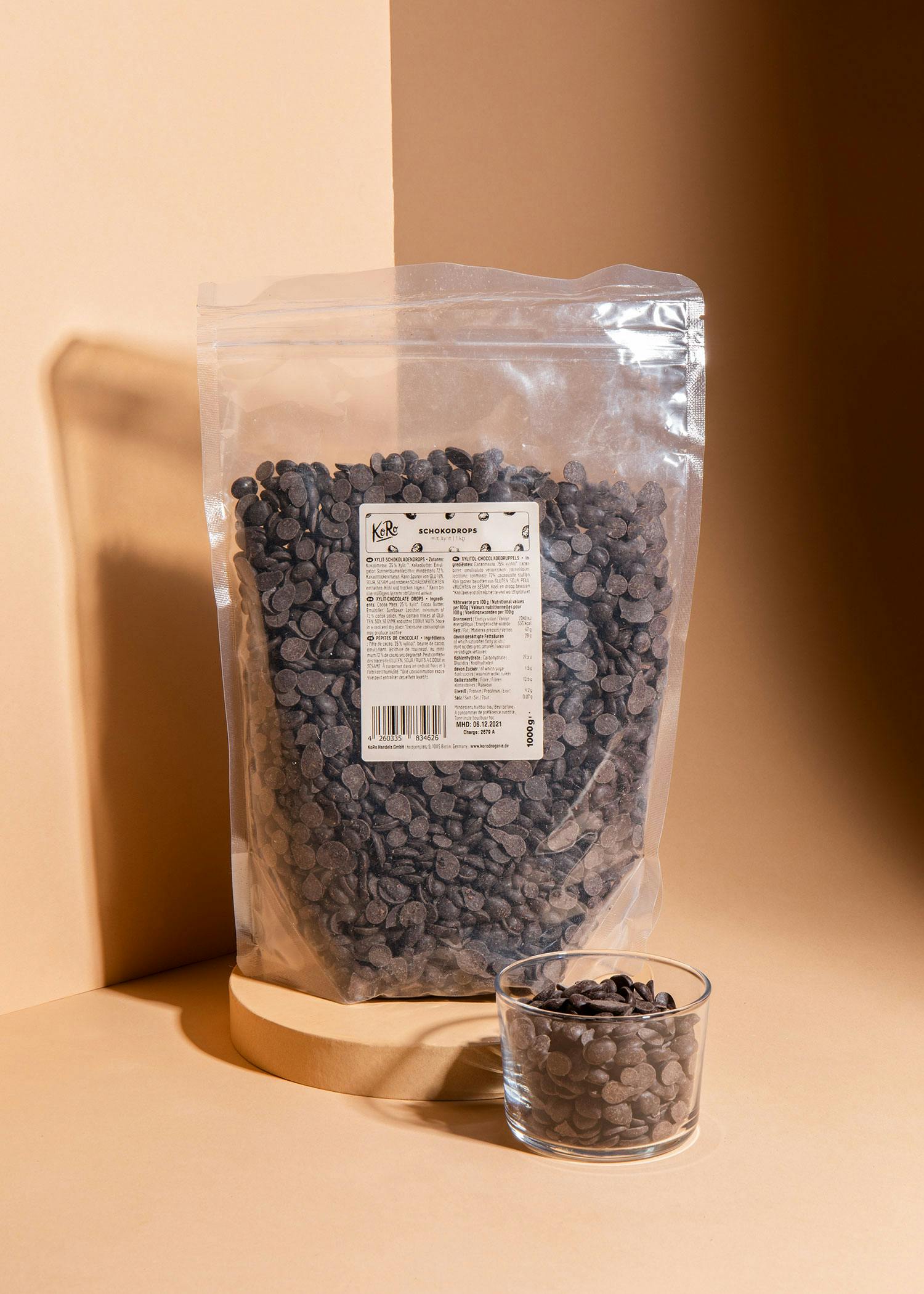 ein Plastikbeutel mit Schokoladenchips steht neben einer Glasschale mit Schokoladenchips