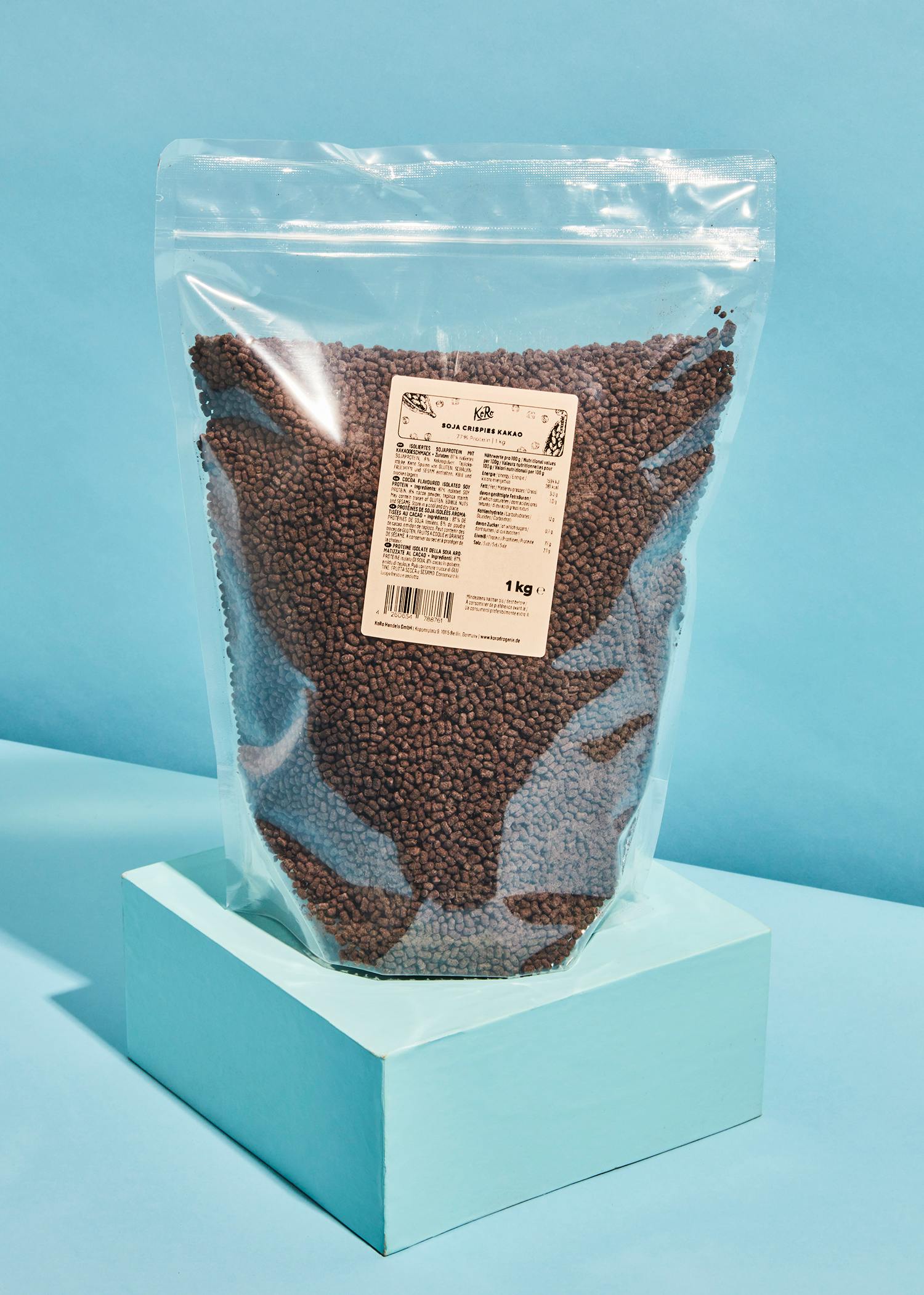 eine Plastiktüte mit braunen Bohnen steht auf einem blauen Tisch
