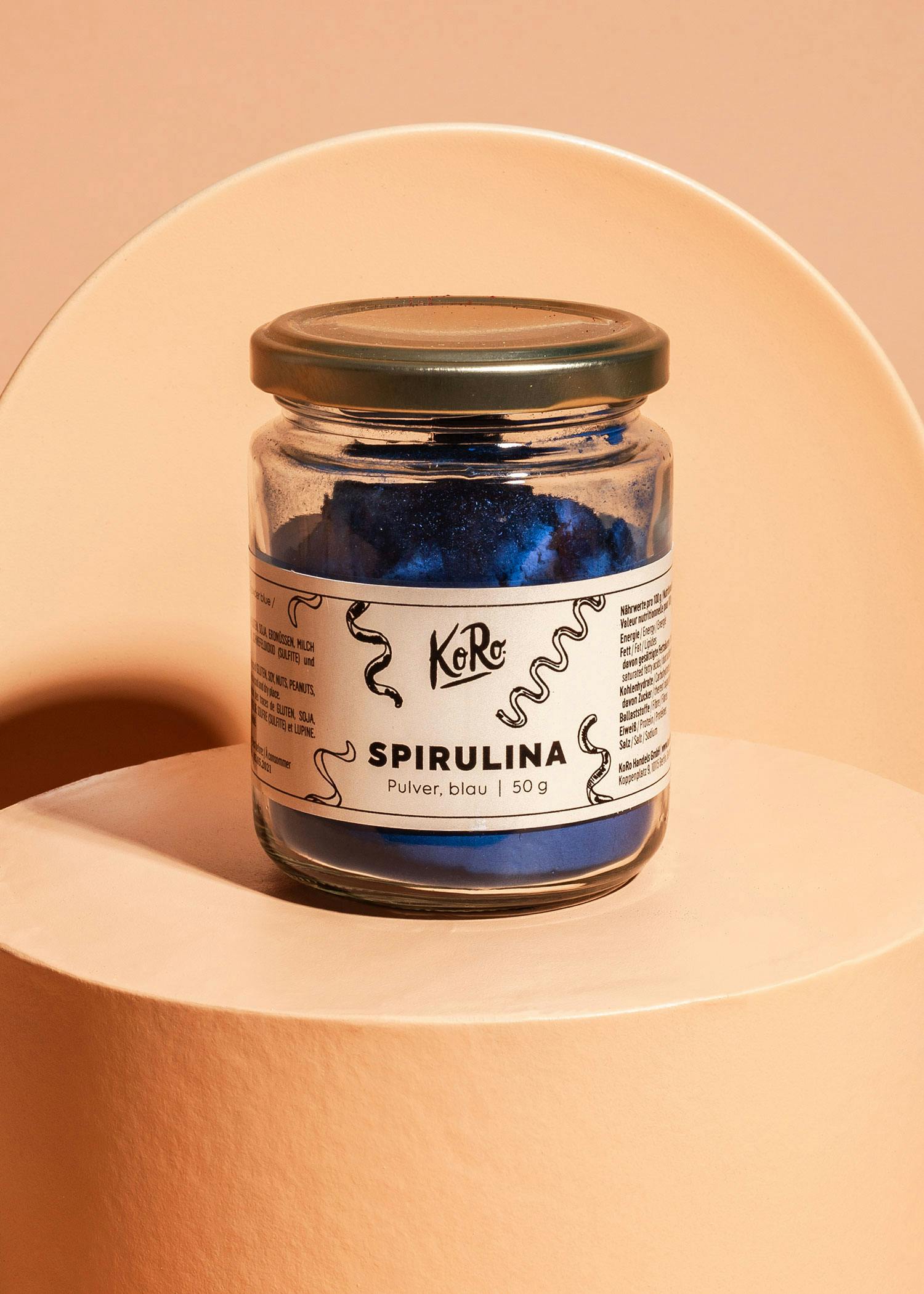 ein Glas mit blauem Pulver und der Aufschrift " spirulina " darauf