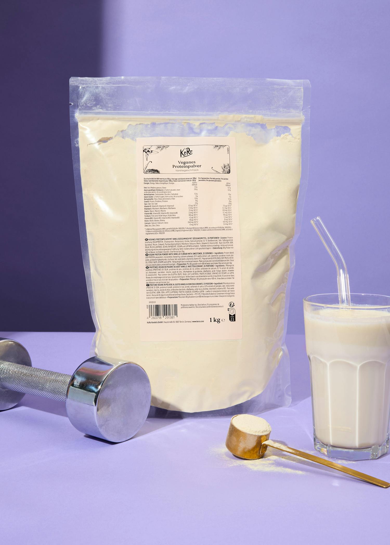 Eine Tüte veganes Eiweißpulver steht neben einem Glas Milch und einem Hantel